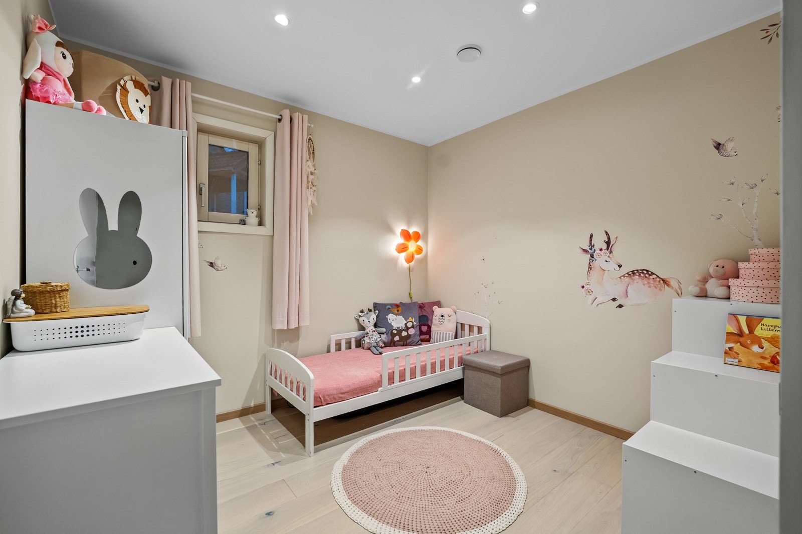 Det innredede rommet fremstår som romslig og velholdt, med nyere laminatgulv som gir et moderne og ryddig uttrykk. De beige veggene skaper en lun og nøytral atmosfære som gjør rommet lett å innrede etter ulike behov. Galleribilde