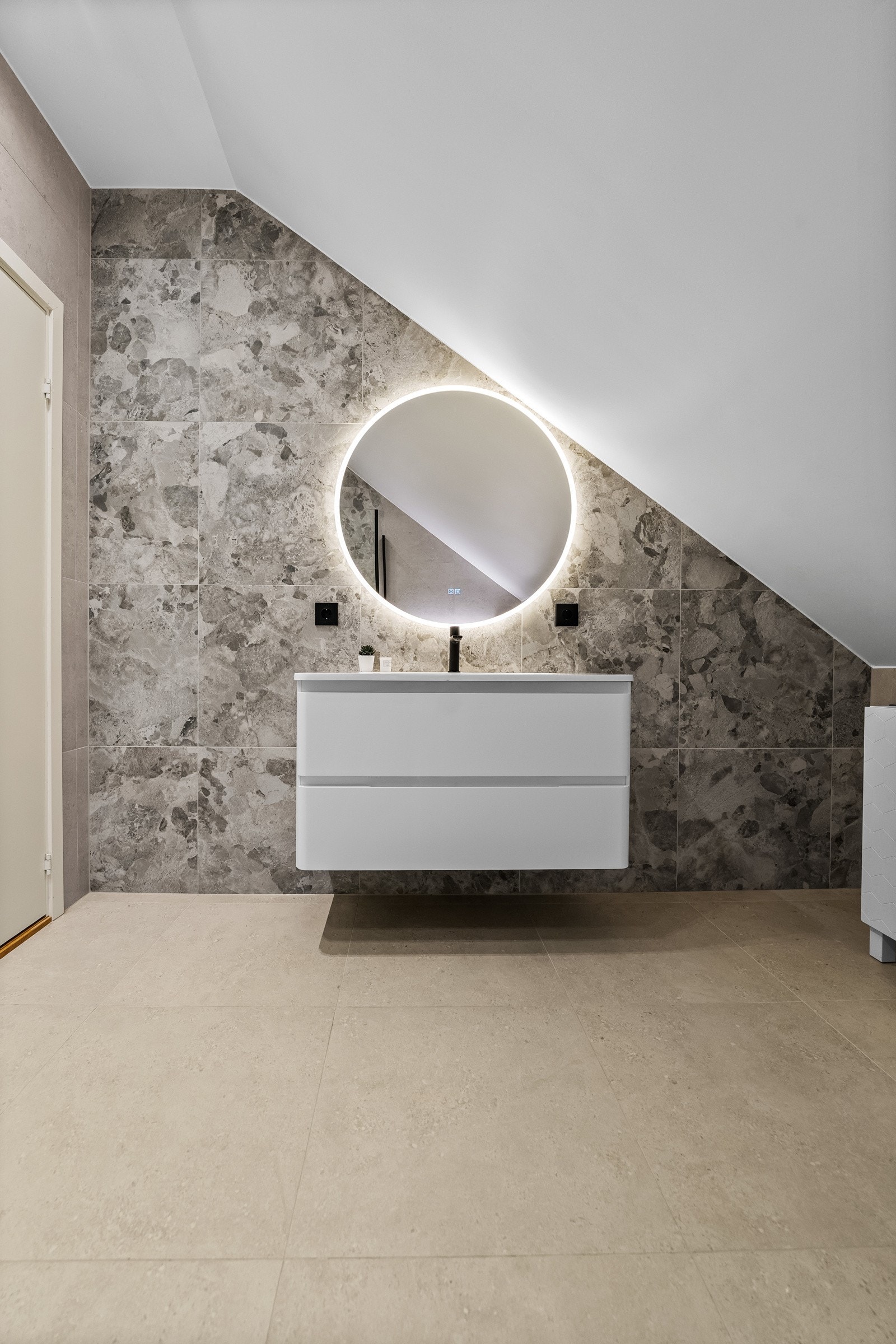 Her er det stilige fliser på gulv og vegg, og badet er innredet med servant med underskap, skap med glatte fronter og veggfestet klosett. Galleribilde