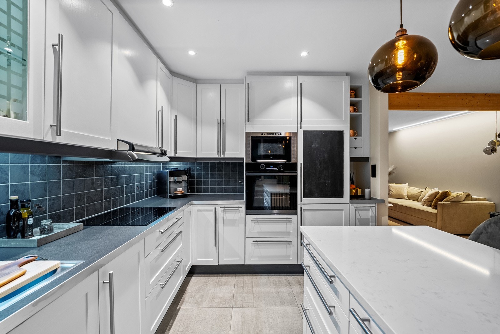 Kjøkkeninnredningen er utformet i en praktisk L-form som gir gode arbeidsflater og rikelig med skap- og benkeplass. Galleribilde