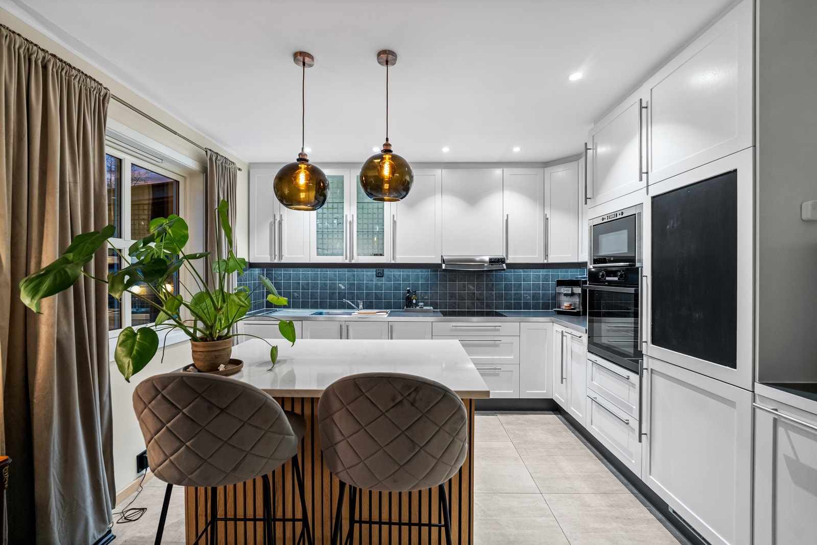 Boligens stue fremstår som romslig og innbydende med en åpen kjøkken- og stueløsning som skaper en luftig og sosial hoveddel. Galleribilde