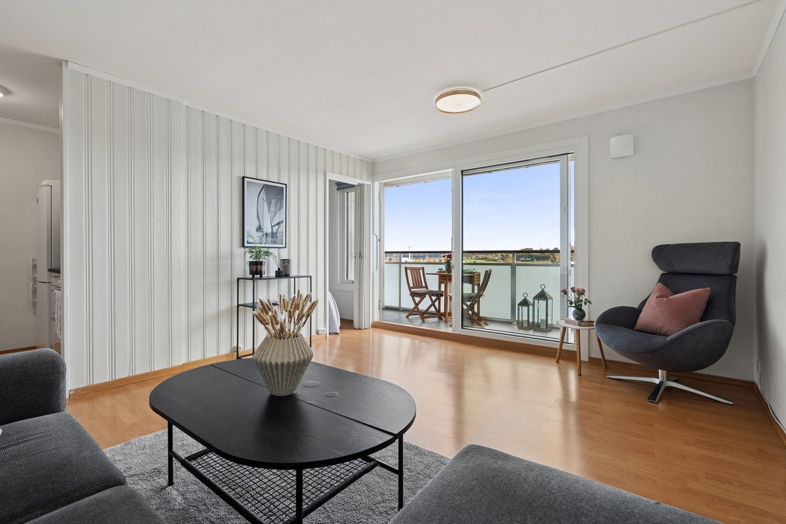 Koselig utsyn fra sofakroken, med stor skyvedør ut til balkongen. Galleribilde