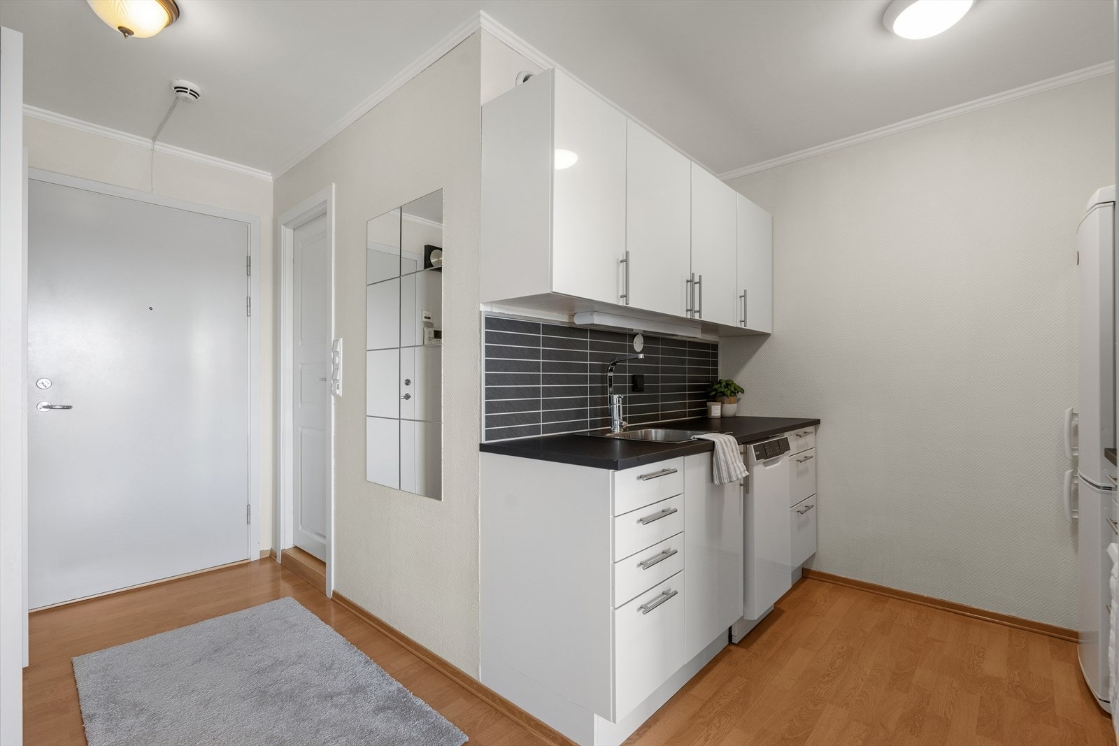 Kjøkkenet har en fin utforming med arbeidsflater på begge siden, og er oppgradert i 2024 med ny benkeplate, oppvaskkum og ny oppvaskmaskin. Galleribilde