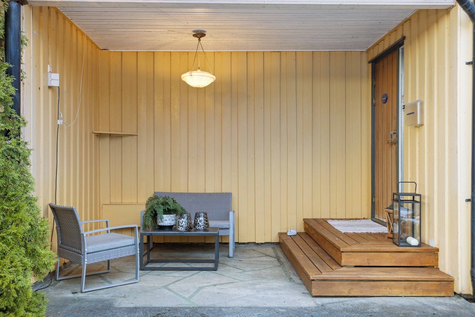 Inngangsparti med plass til sittegruppe under tak. Galleribilde