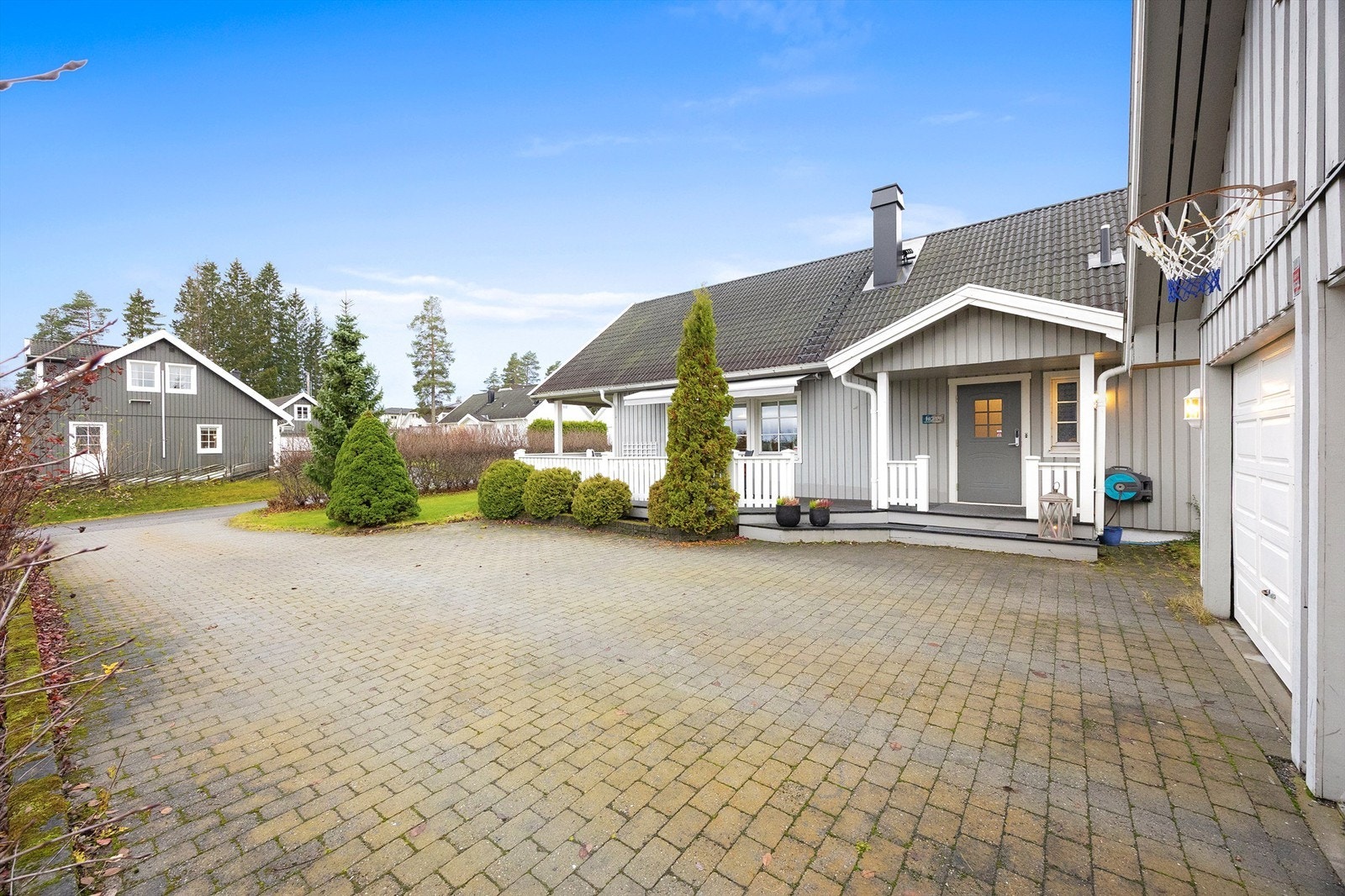 Innbydende gårdsplass belagt med belegningsstein, med rikelig plass til parkering - både her og i den romslige dobbeltgarasjen Galleribilde