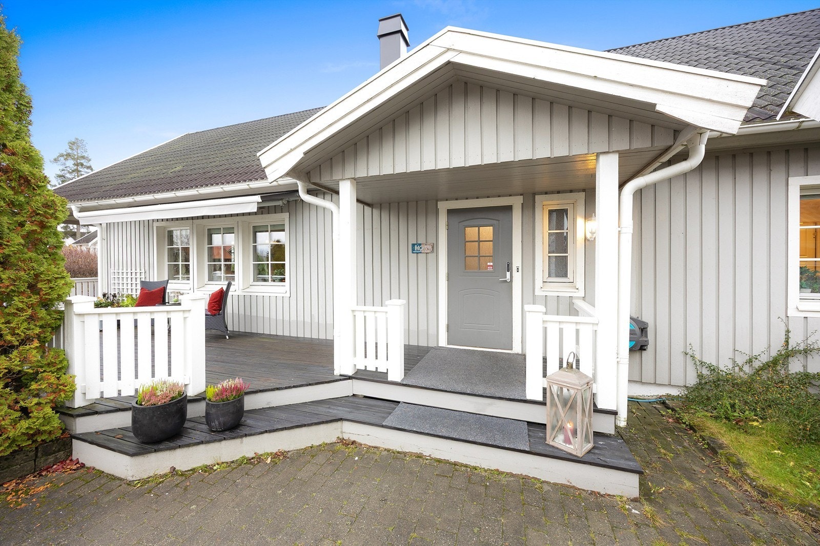 Boligen ønsker deg velkommen med en hyggelig innkjørsel med belegningsstein og et overbygget inngangsparti Galleribilde
