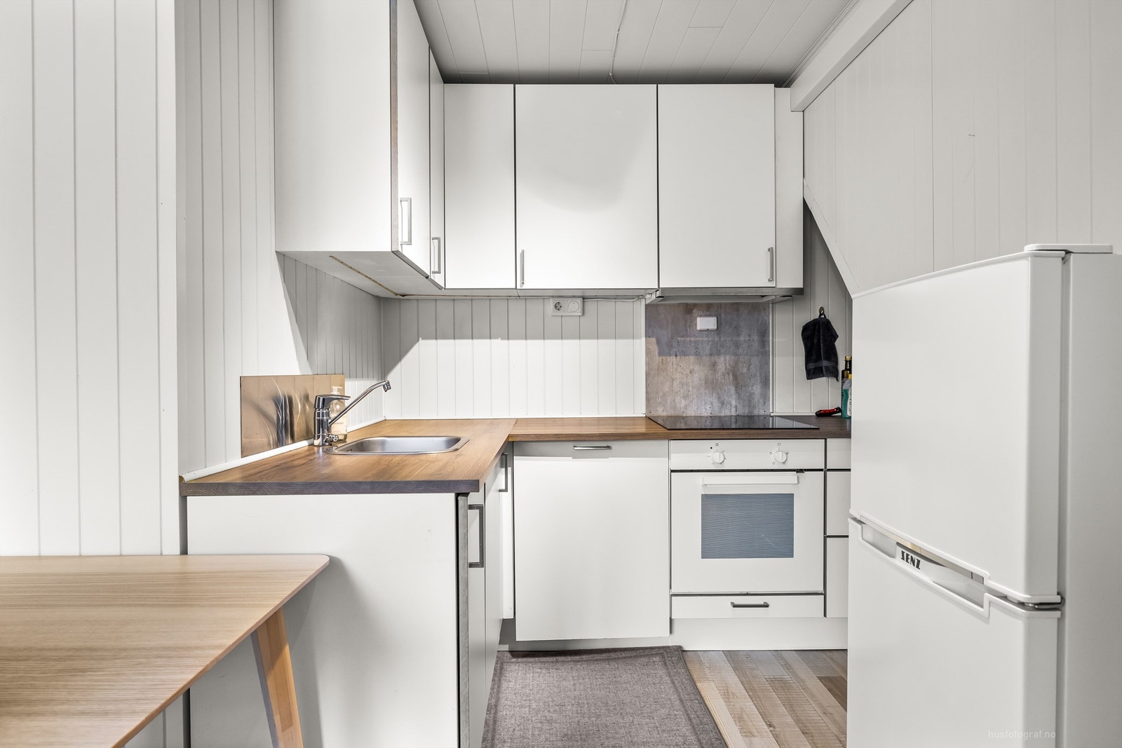 Kjøkkeninnredningen fra 2018 med over- og underskap i hvit samt glatt utførelse - Hybel Galleribilde