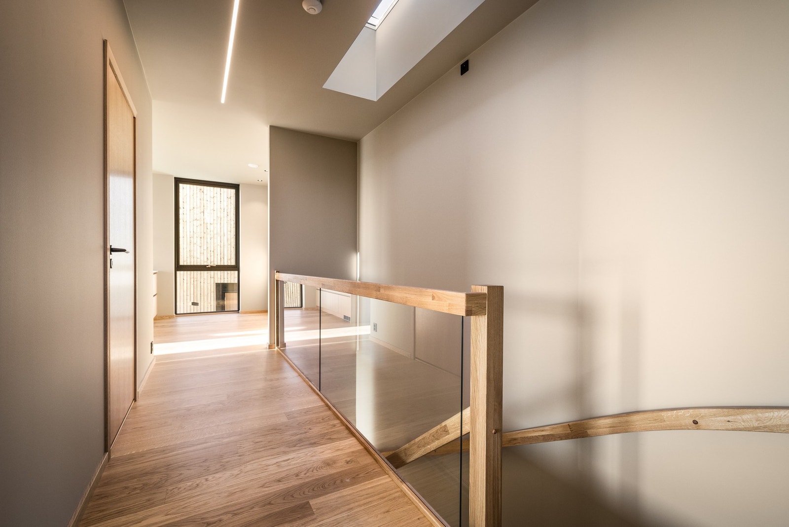 Heltre trapp i stilren utførelse i eik og glass, med overlys-vindu i tak. Galleribilde