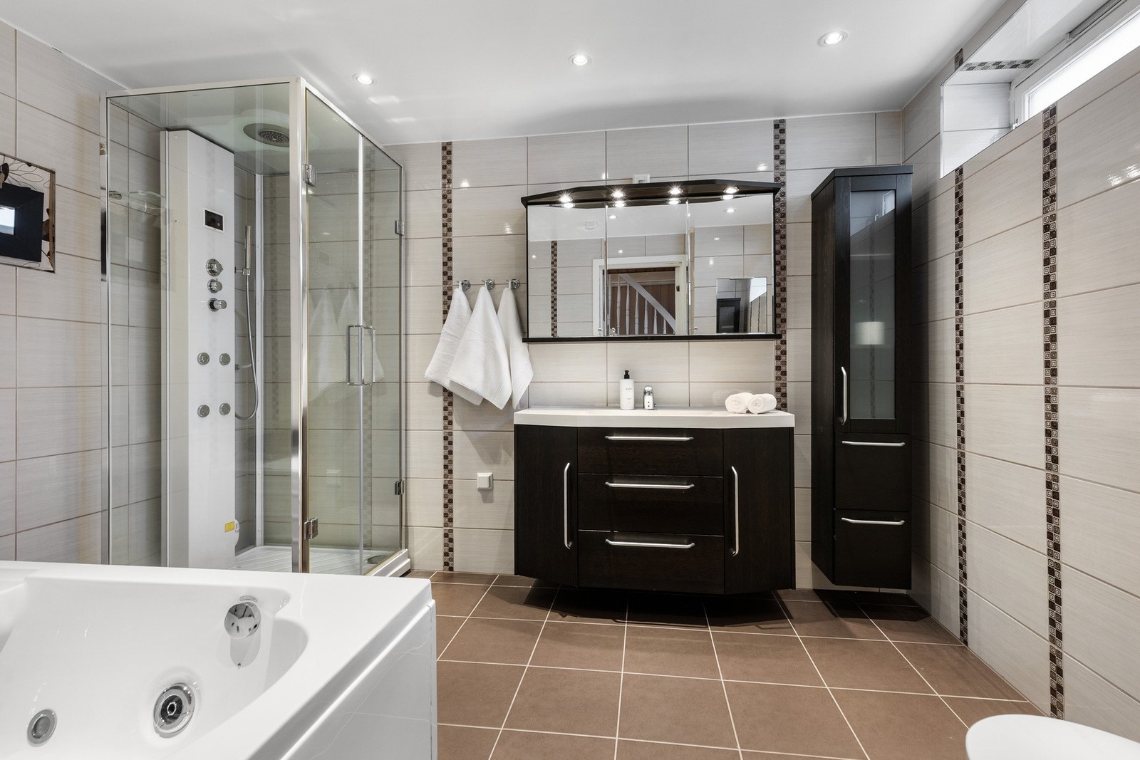 Bad i kjelleretasjen er romslig og innredet med blant annet separat dusjkabinett, servant med innredning og toalett. Galleribilde