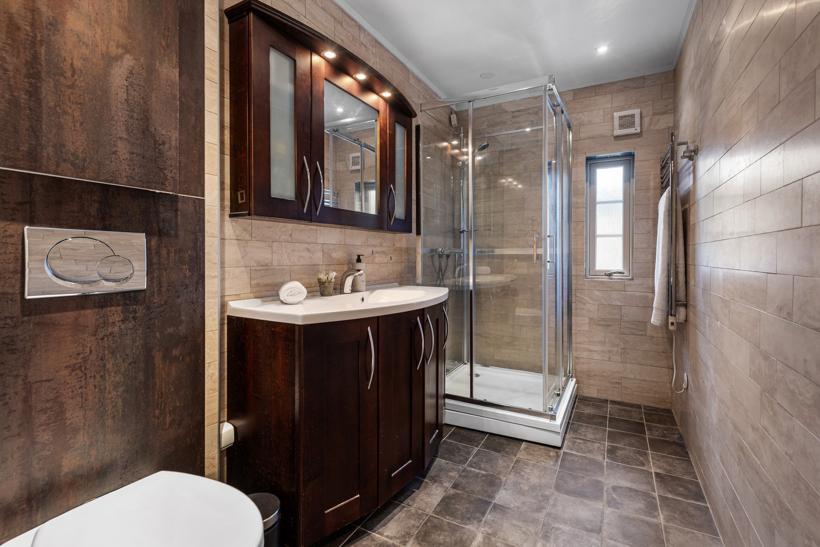 Bad i hovedetasjen er flislagt og innredet med servant med innredning, toalett og dusjløsning. Galleribilde