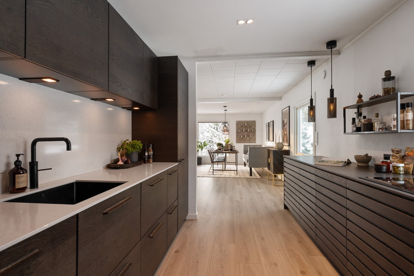 Kjøkkenet har integrerte hvitevarer med kjøleskap, fryseskap i benk, oppvaskmaskin, stekeovn, mikrobølgeovn, vinskap og kaffemaskin Galleribilde