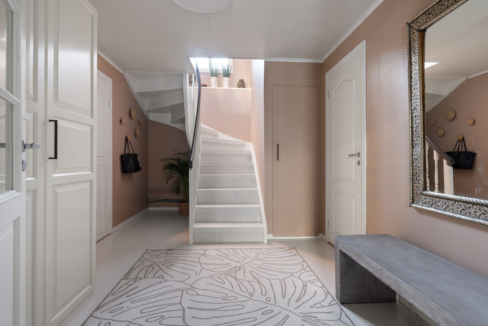 Stor hall med gardrobeløsninger og adkomst til soverom og trapp opp til andre etasje Galleribilde