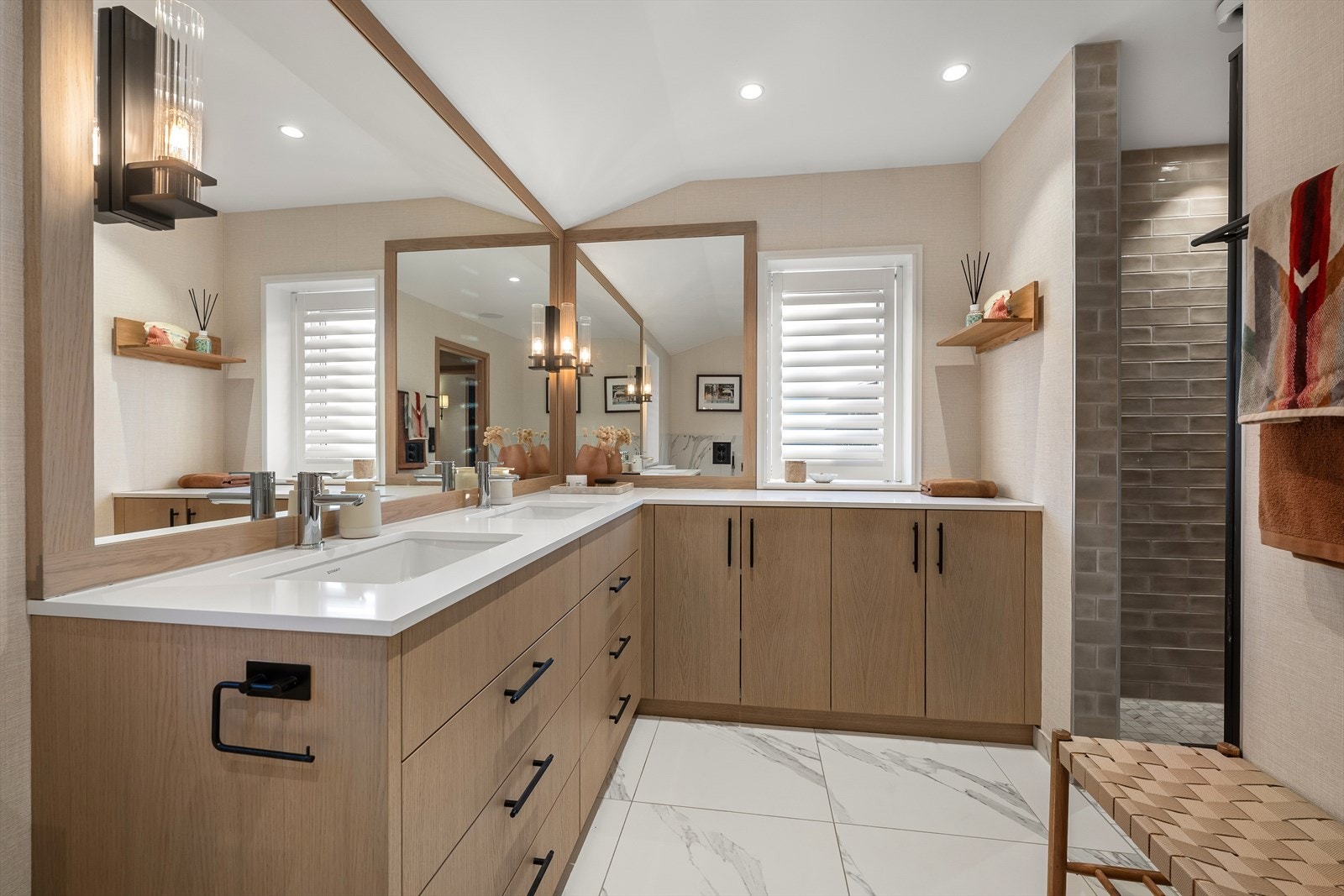 Hovedbadet har plassbygget interiør i eik fra Luxera med Silestone benkeplate, stor dusjnisje med armatur fra Tapwell, badekar, toalett, flislagte overflater, eksklusiv baderomstapet, spotbelysning og lekre vindusshutters fra Weba Galleribilde