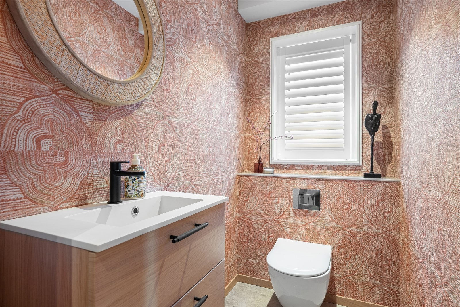 I tilknytning til gangen finnes et elegant gjeste-wc med Jura Grey-fliser på gulv, varmekabler, eksklusiv tapet og lekre vindusshutters fra Weba Galleribilde