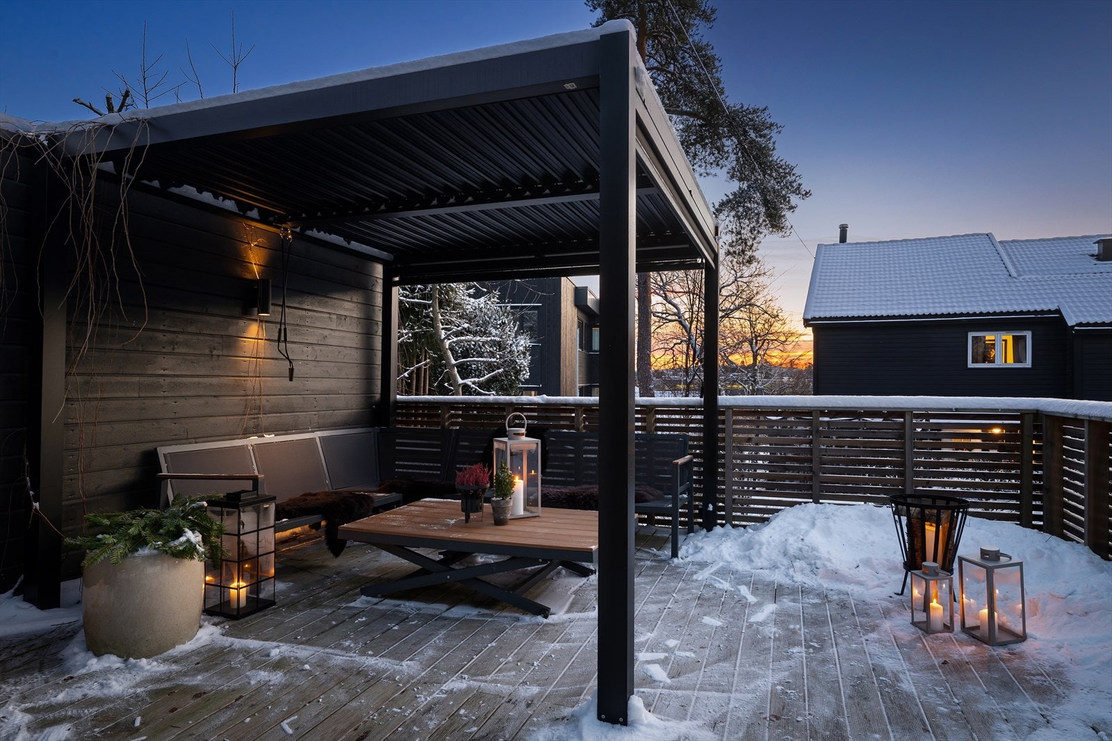 Stor platting på 35 m² i tilknytning til garasjen med pergola, utebelysning og en stor markise som dekker grillområdet Galleribilde