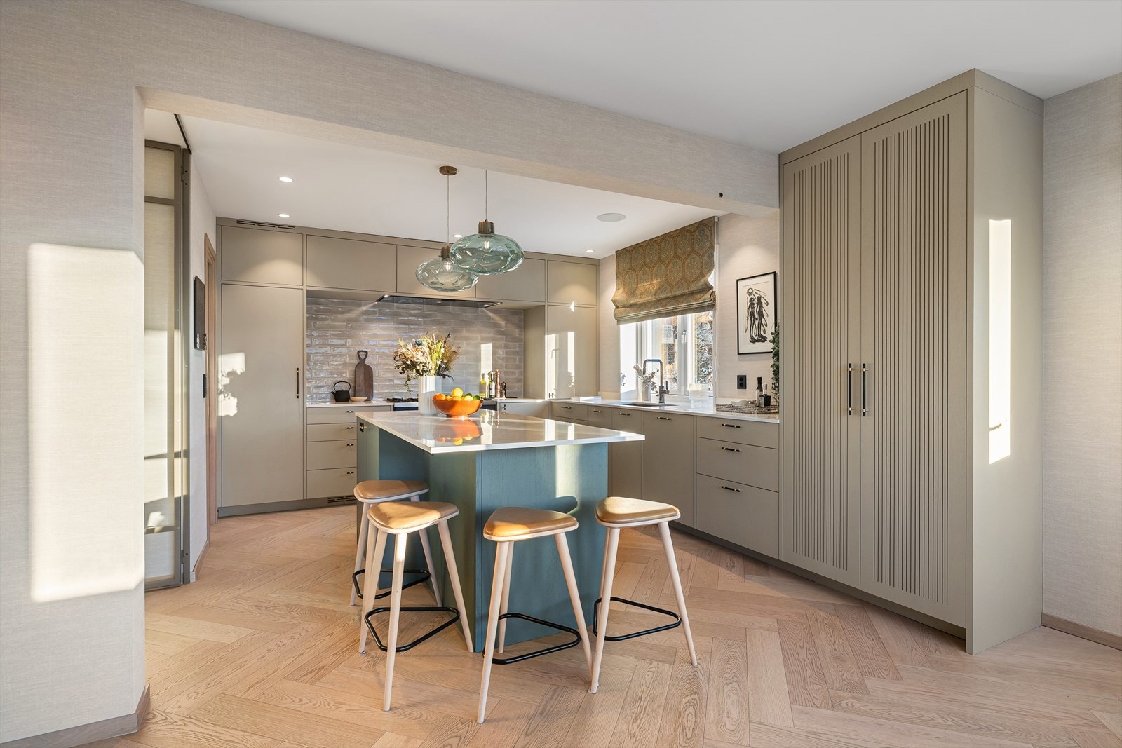 Kjøkkenet har rikelig med skap- og benkeplass, gode arbeidssoner og en romslig kjøkkenøy som gir både ekstra lagringsplass og en naturlig samlingsplass Galleribilde