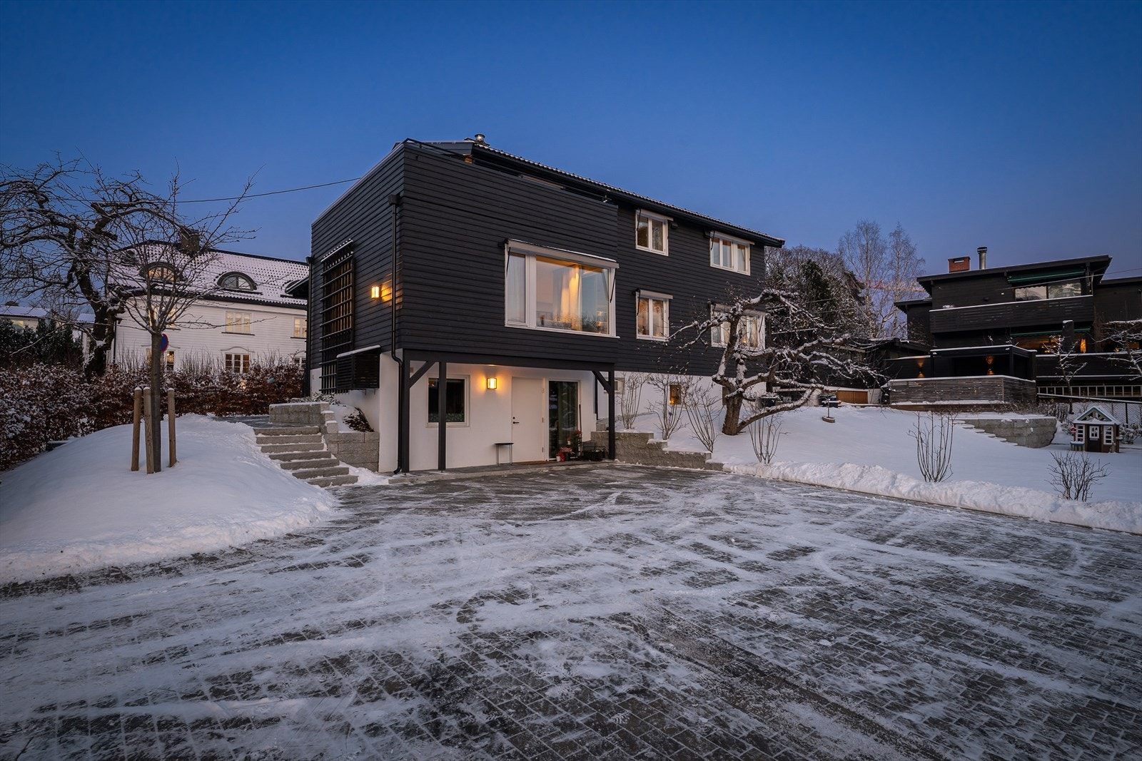 Stor steinbelagt gårdsplass med 4 biloppstillingsplasser - Det er også en innholdsrik kjedet dobbelgarasje Galleribilde