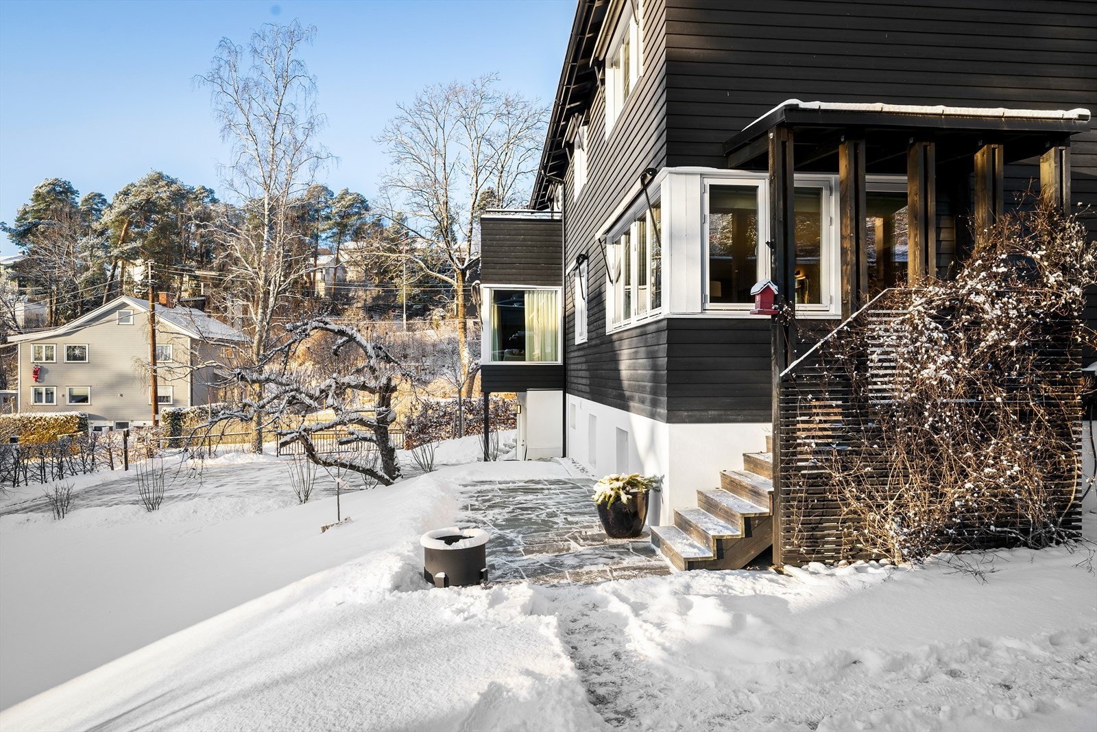 Den skiferbelagte plattingen har gode møbleringsmuligheter, og har av selger blitt møbelert med en hyggelig sittegruppe og beplantning Galleribilde