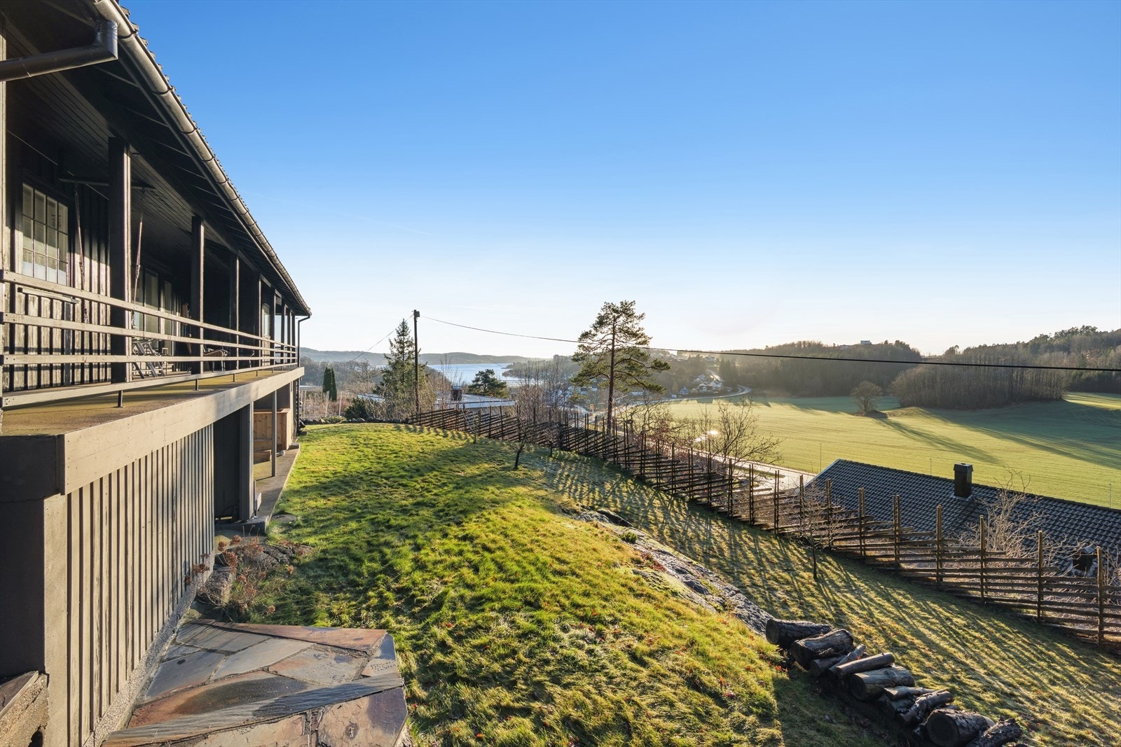 Romslig inngjerdet hage og uteområder som bader i sol Galleribilde