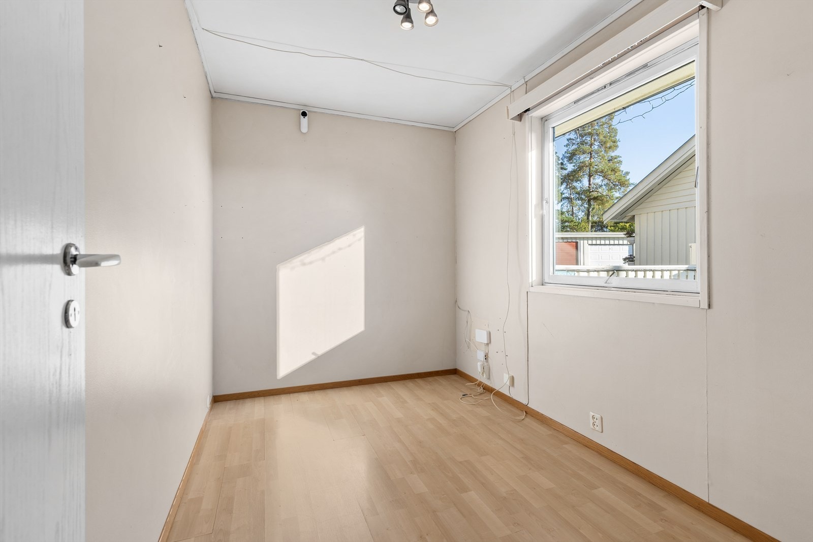 Det andre soverommet i etasjen har laminatgulv og vegger med tapetserte overflater. Galleribilde