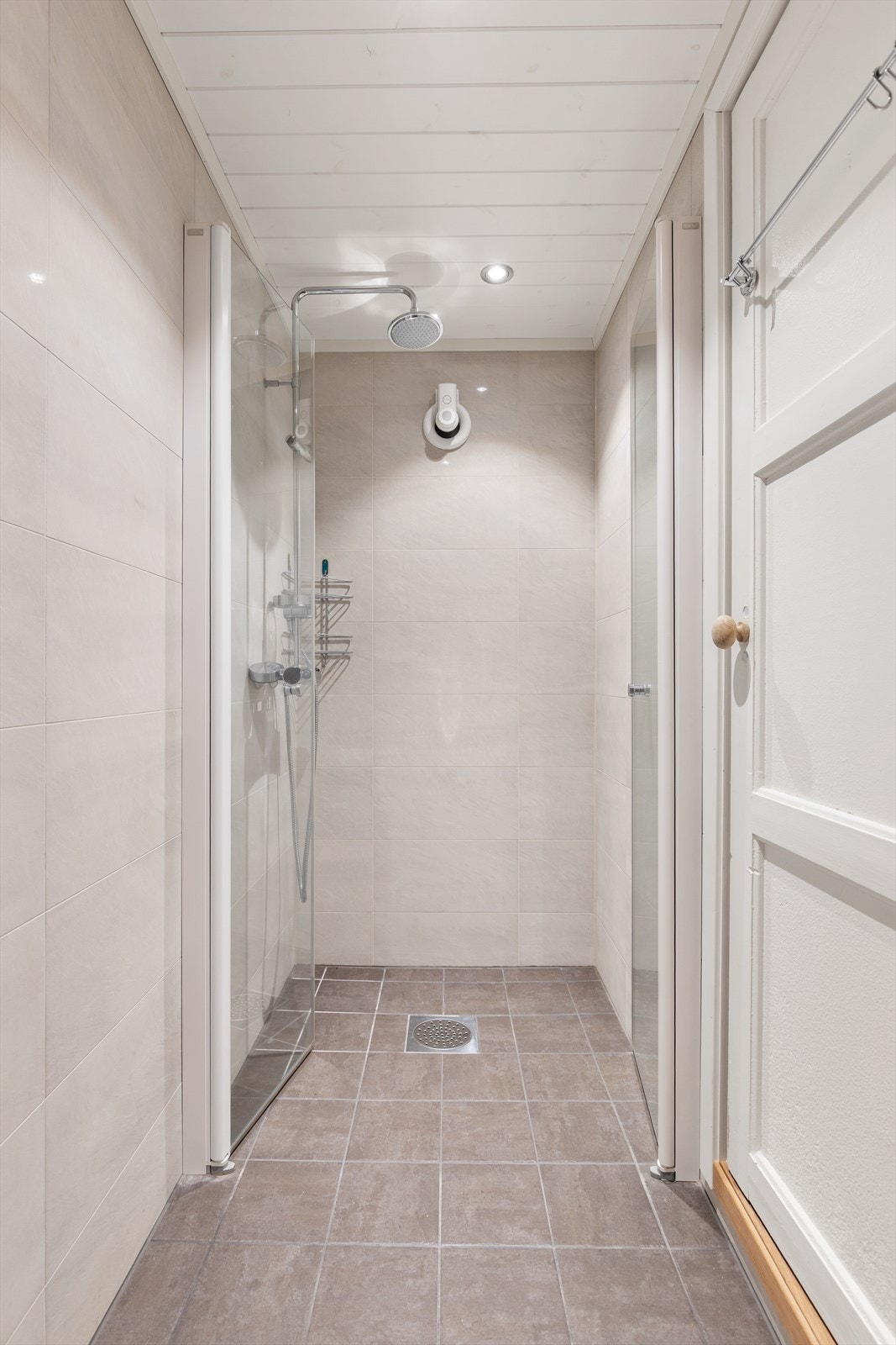 Moderne bad fra 2015 med flislagt gulv og vegger, gulvvarme og et praktisk dusjhjørne. Galleribilde