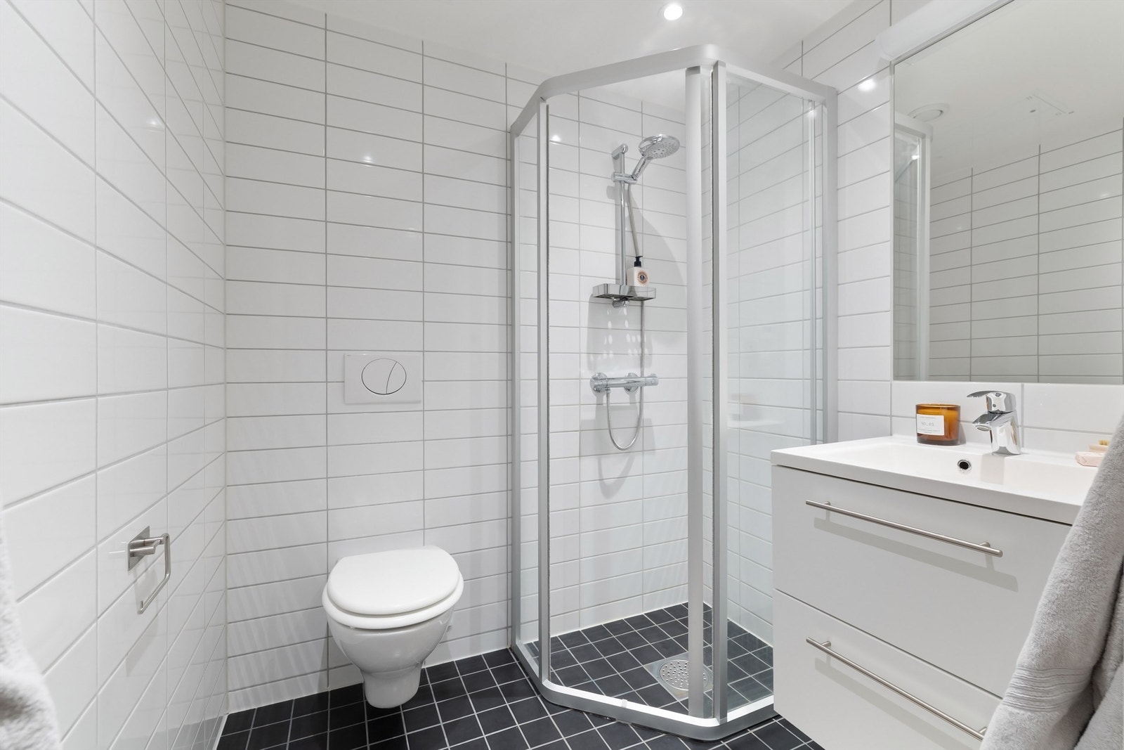 Bad 2 - Vegghengt toalett med innebygget sisterne. Dusj på gulv med skyvedør av glass. Dusjarmatur tilkoblet veggmontert hånddusj. Galleribilde