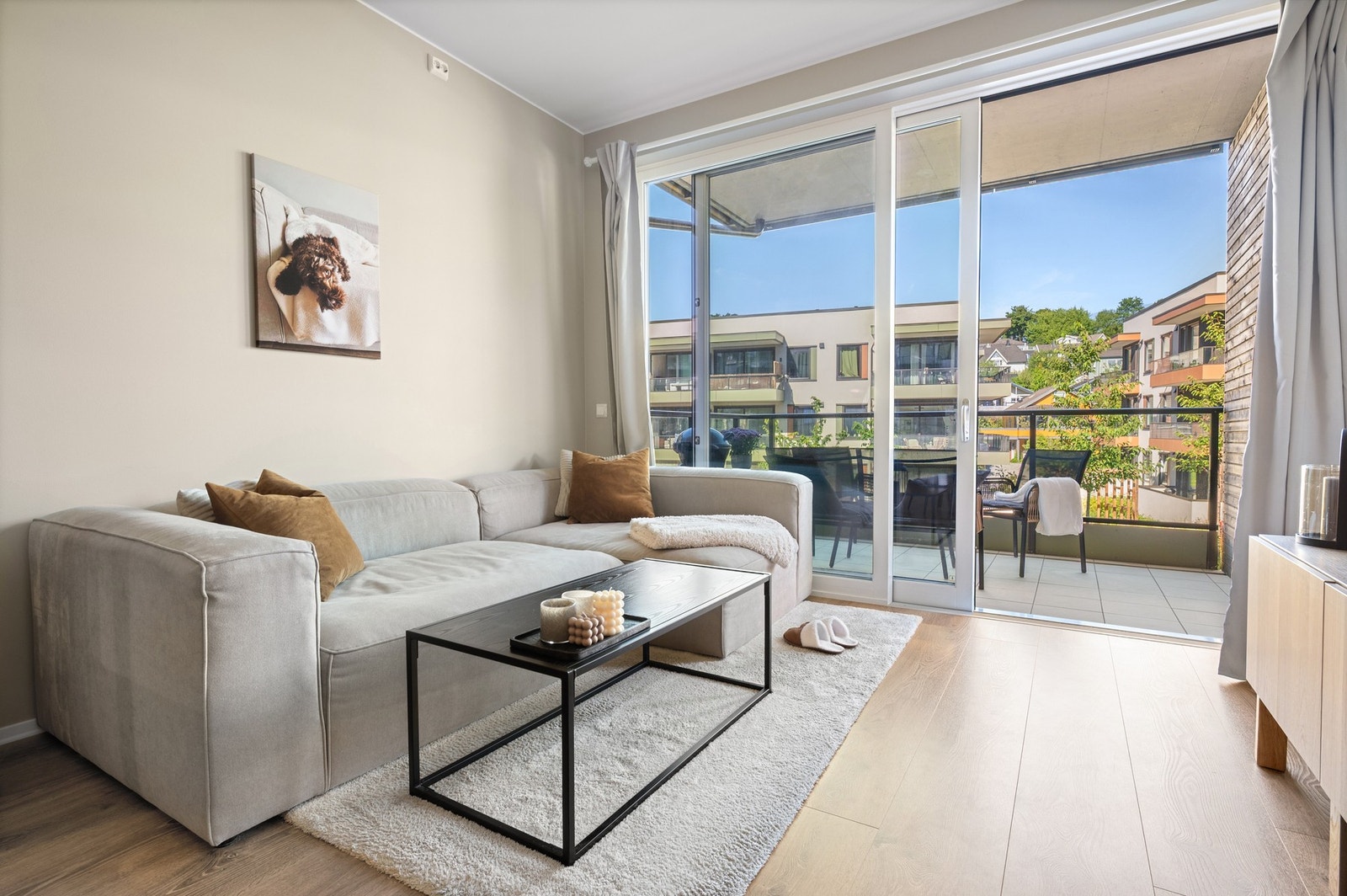 Lys og moderne stue med store vindusflater og utgang til balkong. Galleribilde