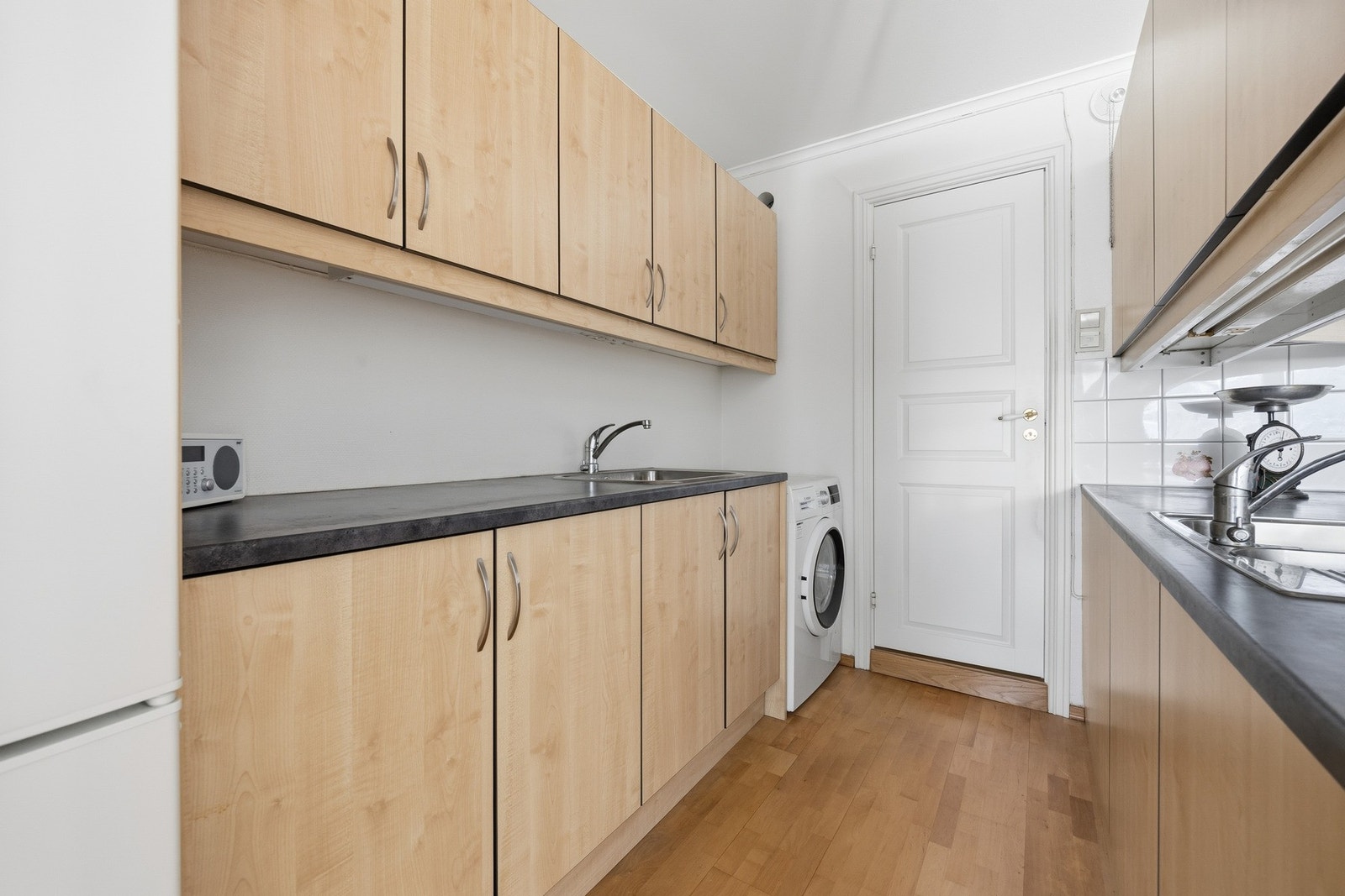 Grovkjøkken med nisjer for oppvaskmaskin og kjøl-/fryseskap. Galleribilde