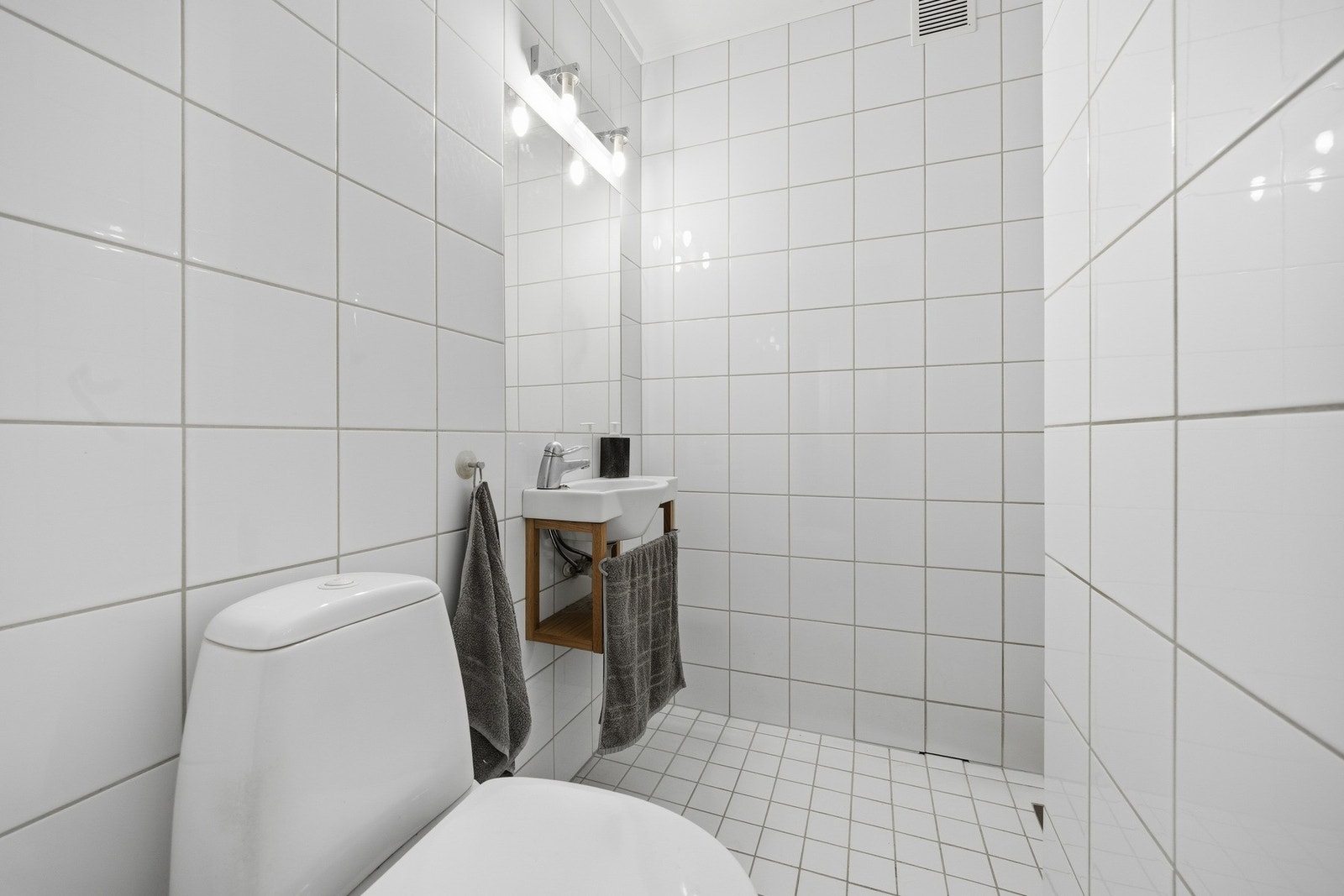 Baderom med lyse fliser på vegger og gulv. Galleribilde