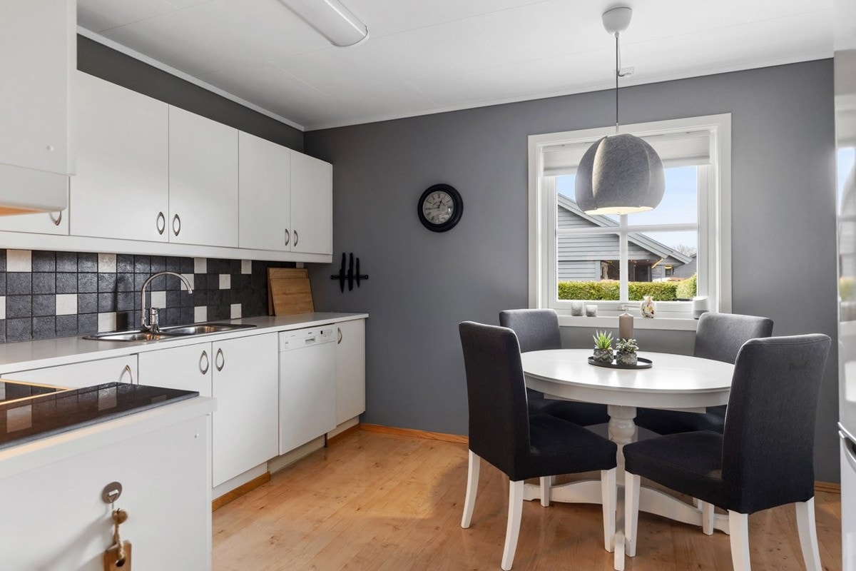 Koselig kjøkken i hvit utførelse med plass til spisebord. Galleribilde