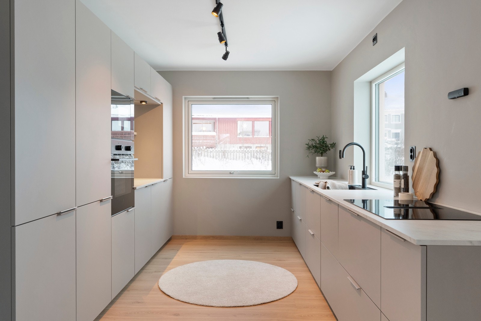 Kjøkkenet er både funksjonelt og stilfullt, med integrert platetopp, samt stekeovn og mikrobølgeovn plassert i praktisk ståhøyde. Galleribilde