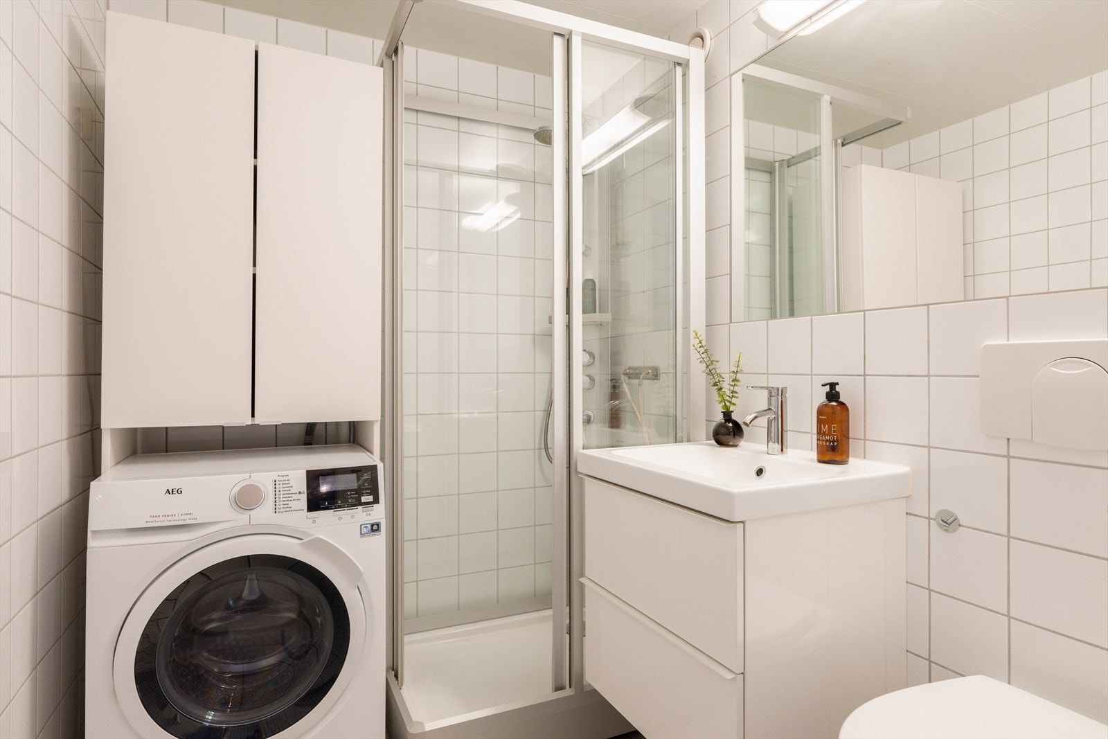 Rommet er utstyrt med servantskap, speil og dusjkabinett med skyvedør. Galleribilde