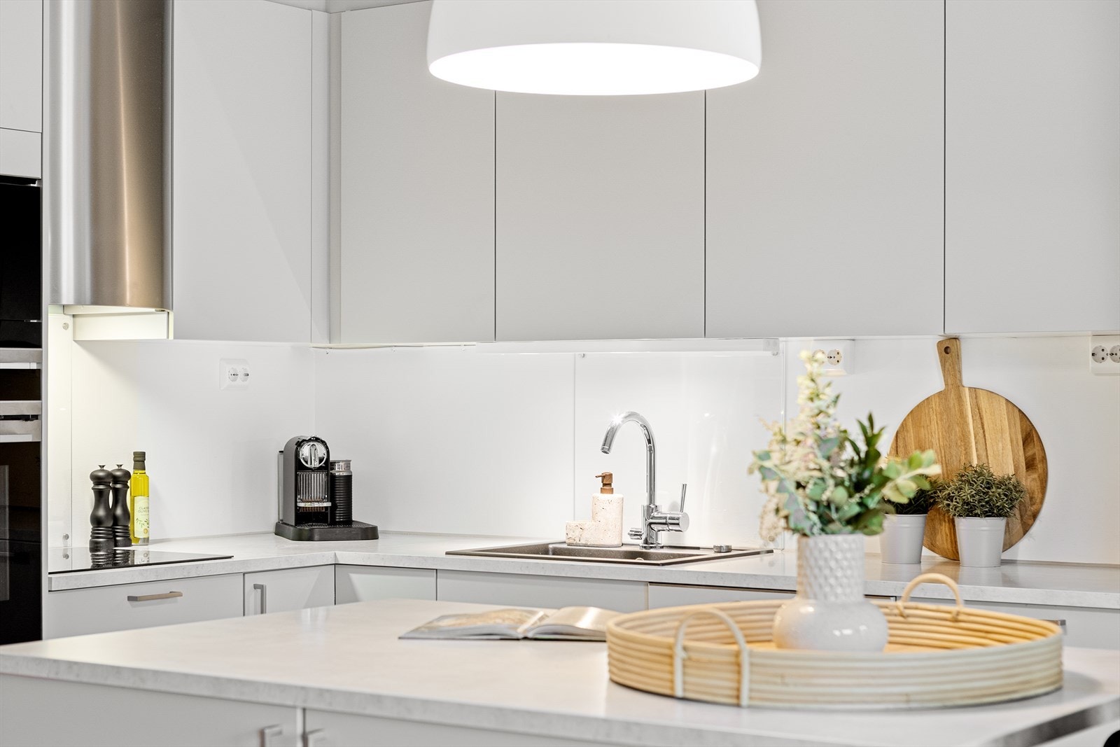 Innredningen har lysegrå, glatte fronter, takoppforede skap og lys laminatbenkeplate med nedfelt kum i kompositt. Galleribilde