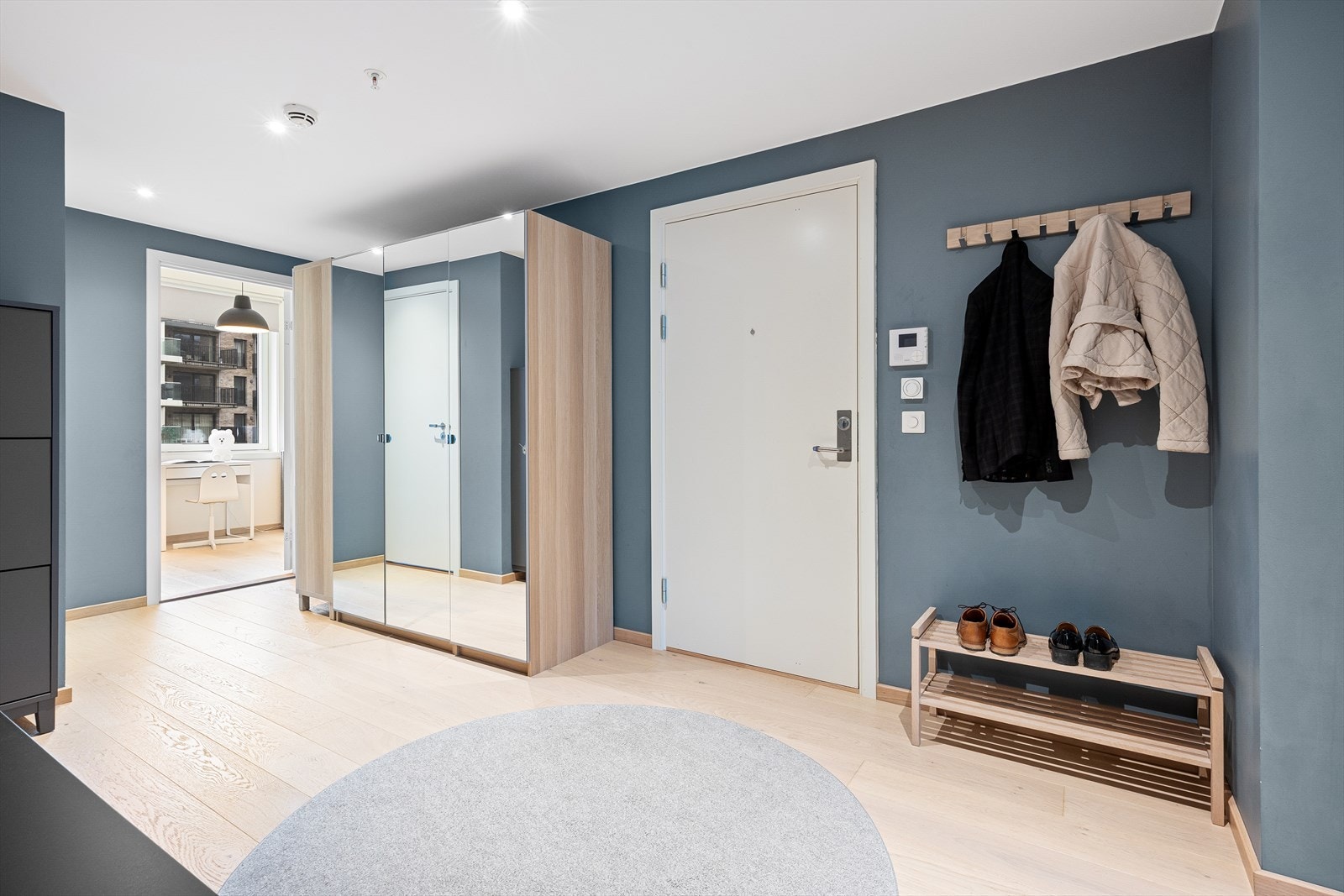 De blåmalte veggene i entreen fremhever det gylne parkettgulvet. Galleribilde