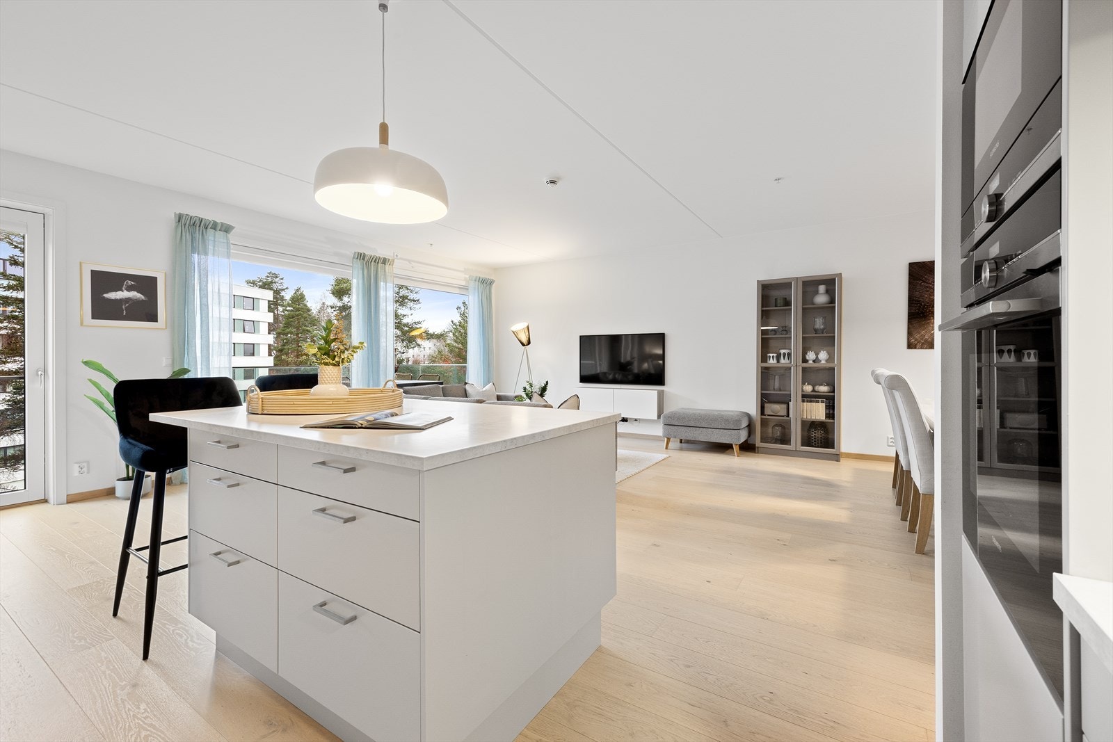 I overgangen til stuen er det en praktisk kjøkkenøy med barløsning og ekstra skap- og benkeplass. Galleribilde