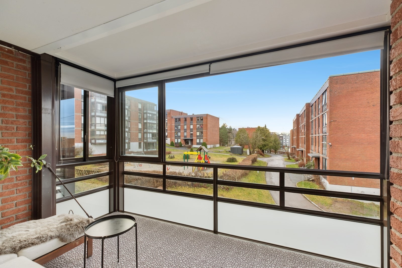 Fra balkongen er det utsikt mot sameiets hyggelige fellesarealer. Glasspartiene kan skyves helt til side for å åpne opp på varme dager. Galleribilde