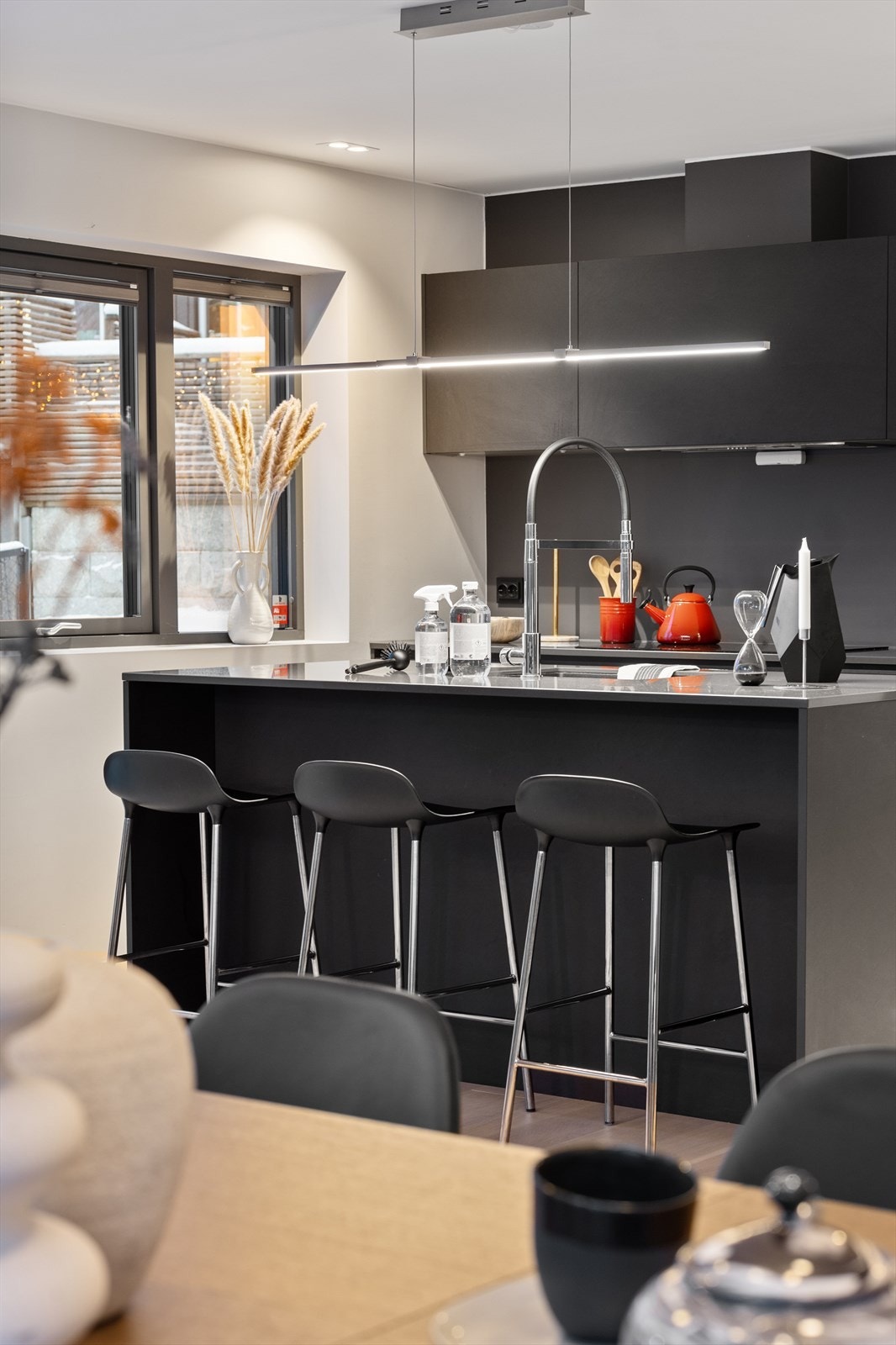 Kjøkkenet er stilrent og gjennomført med kjøkkeninnredning i sorte, glatte fronter som gir et moderne og eksklusivt uttrykk. Galleribilde