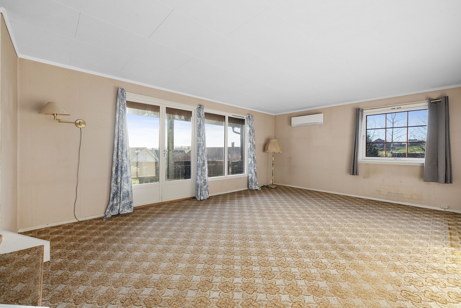 Stuen fremstår som hyggelig og romslig med gode lysforhold gjennom store vindusflater Galleribilde