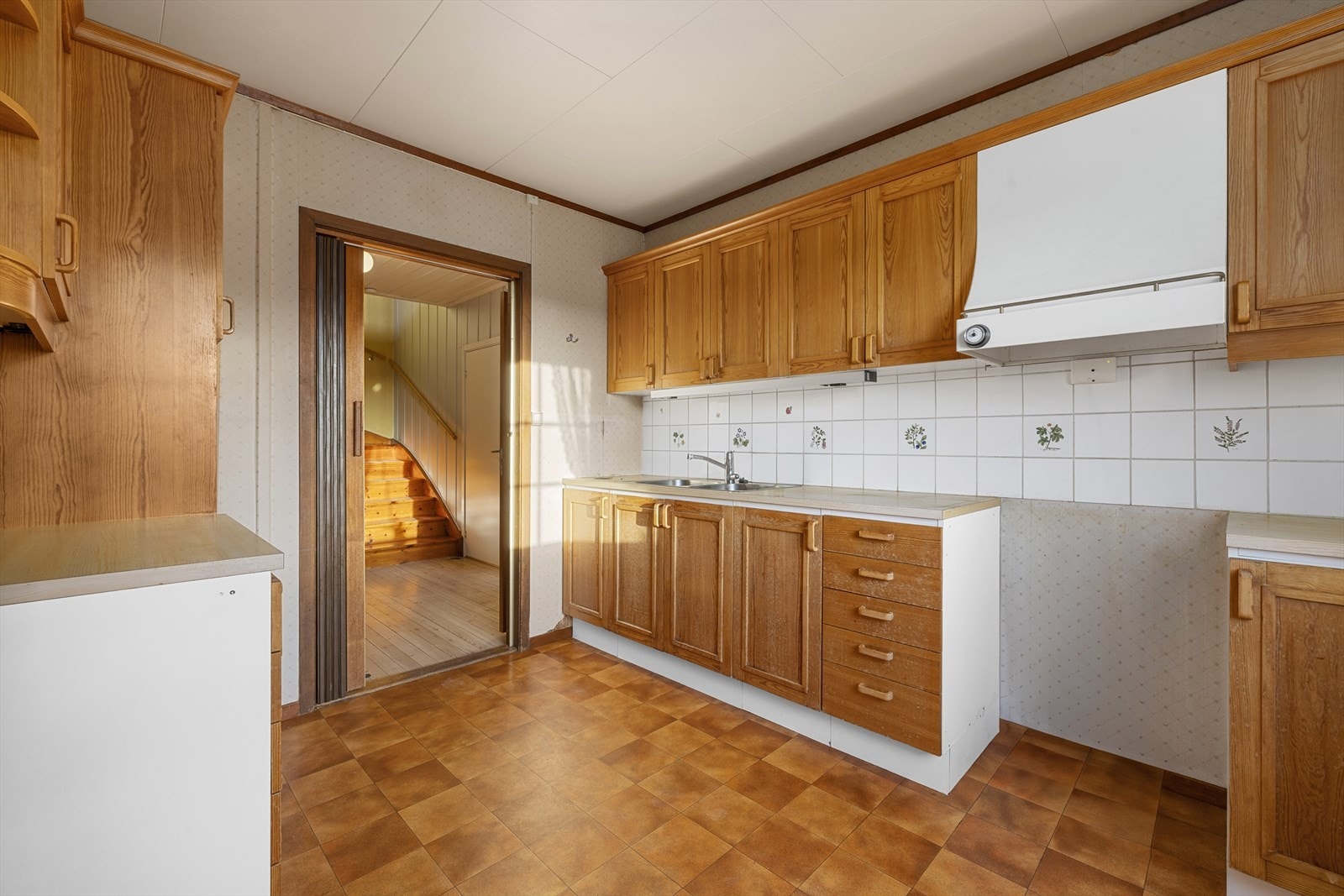 Eldre kjøkkeninnredning med heltre profilerte fronter på over- og underskap samt skuffer Galleribilde