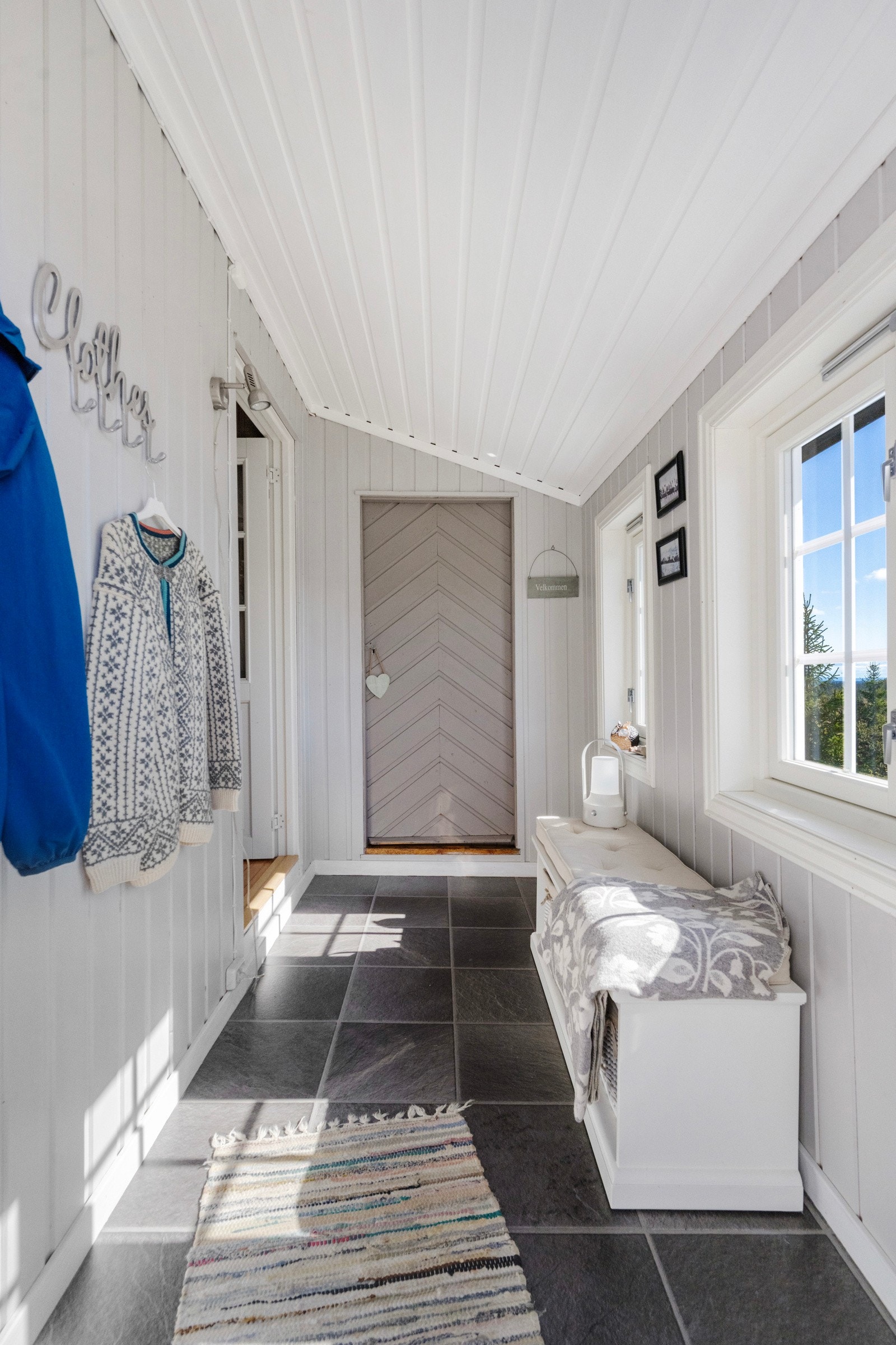 Lys og innbydende gang med plass til yttertøy og sko Galleribilde