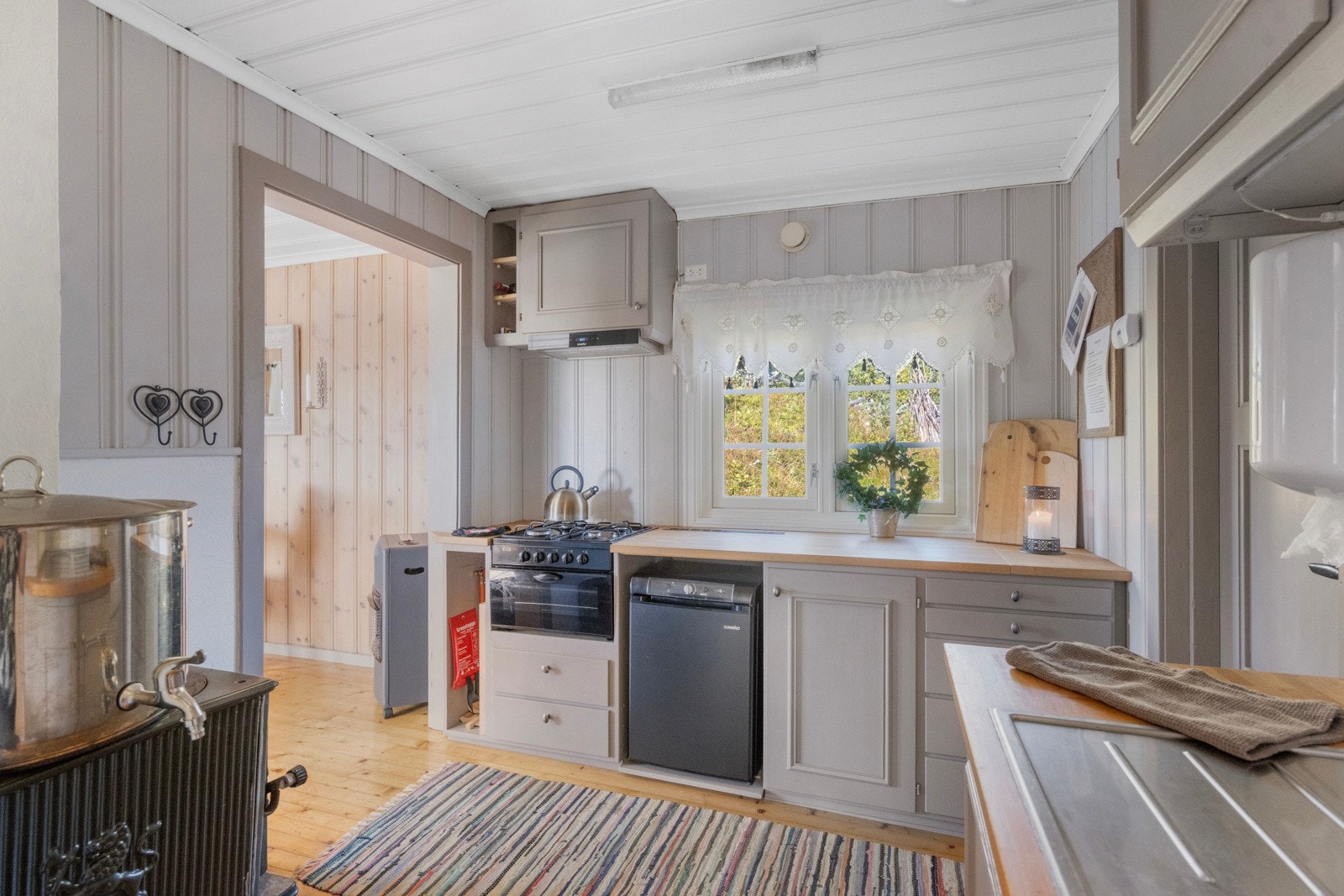 Kjøkkenet er enkelt, men praktisk, med eldre innredning fra 2014 som inkluderer under- og overskap med profilerte fronter og benkeplate med nedfelt vask Galleribilde