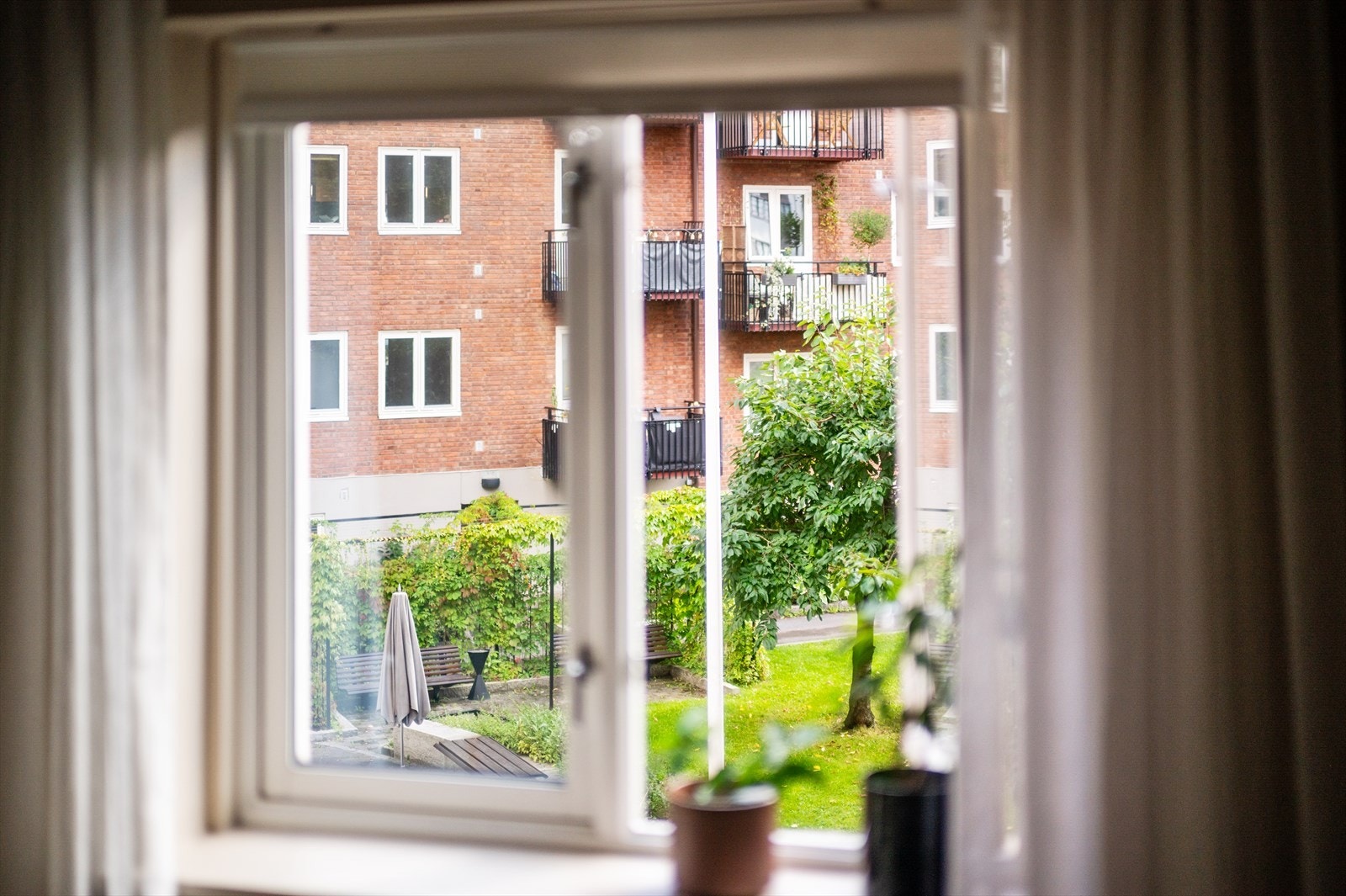 Det er hyggelig utsikt fra både stue og kjøkken mot den pent opparbeidede og frodige bakgården Galleribilde