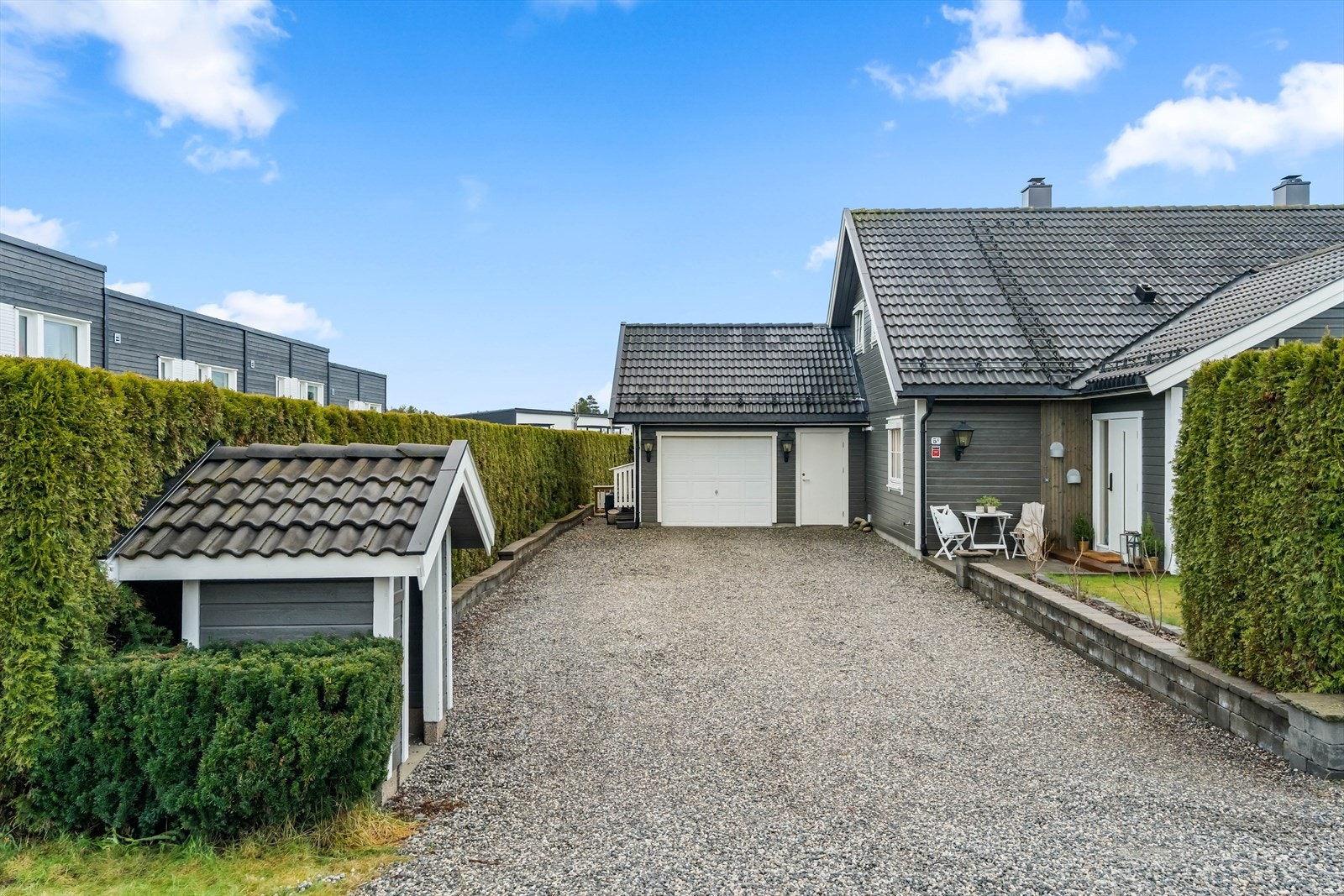 Tomten er pent opparbeidet med hekk og plen, og varme dager kan nytes på begge sider av boligen. Galleribilde