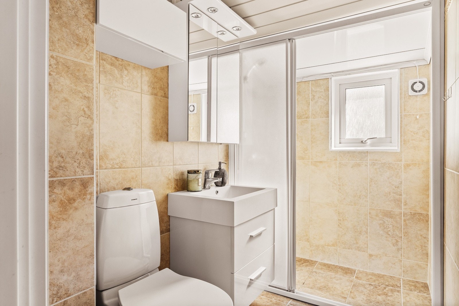 Badet har gulvvarme og er flislagt på gulv og vegger med panel i taket. Galleribilde