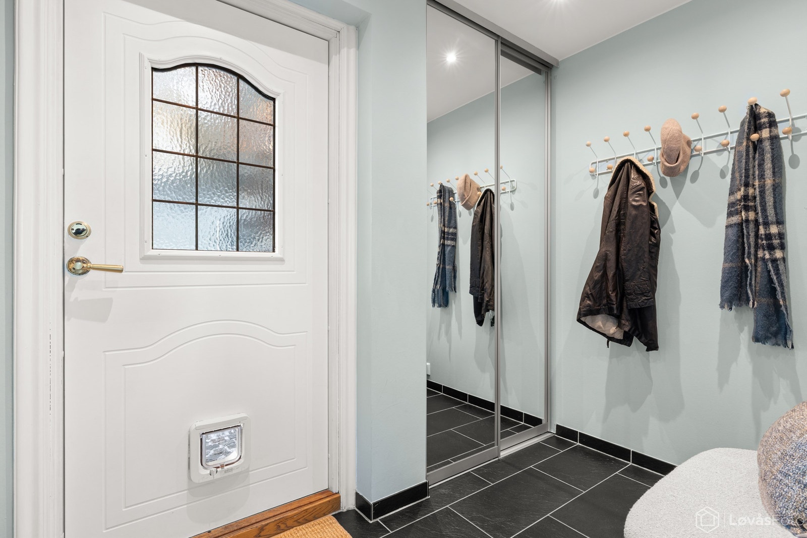 Romslig entré med gulvfliser med gulvvarme og skyvedørsgarderobe Galleribilde