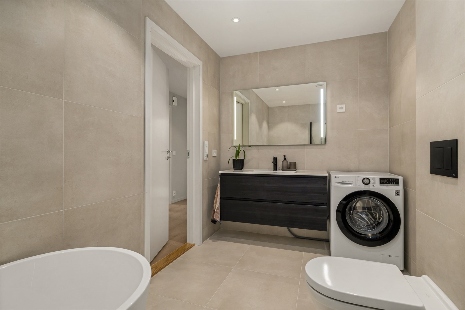 Baderommet har også servant i innredning og opplegg for vaskemaskin og tørketrommel Galleribilde