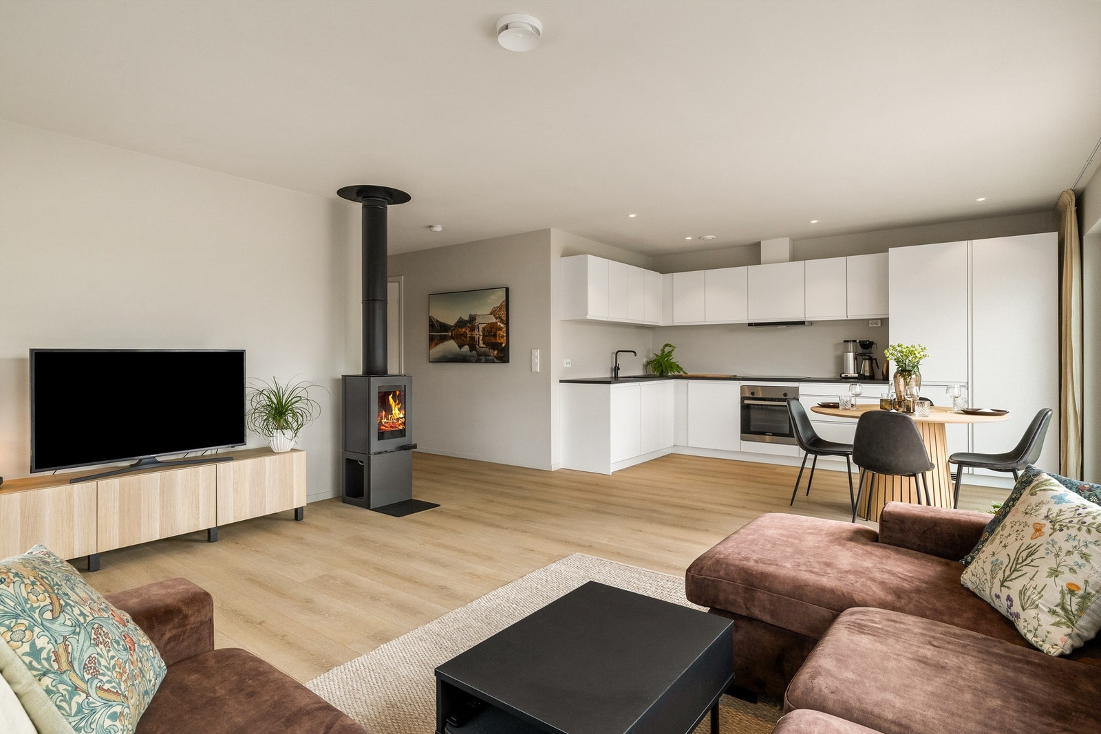 Stuen og kjøkkenet som ligger i åpen løsning skaper et meget sosialt rom Galleribilde