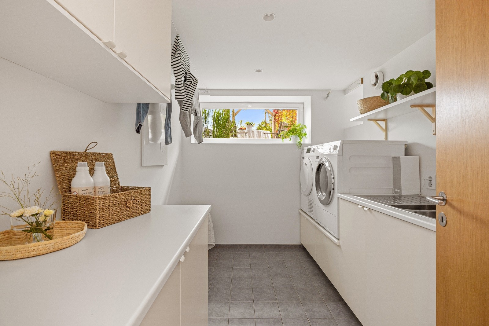 Eget vaskerom i underetasjen med godt med benk- og oppbevaringsplass i tillegg til opplegg for vaskemaskin og tørketrommel. Galleribilde