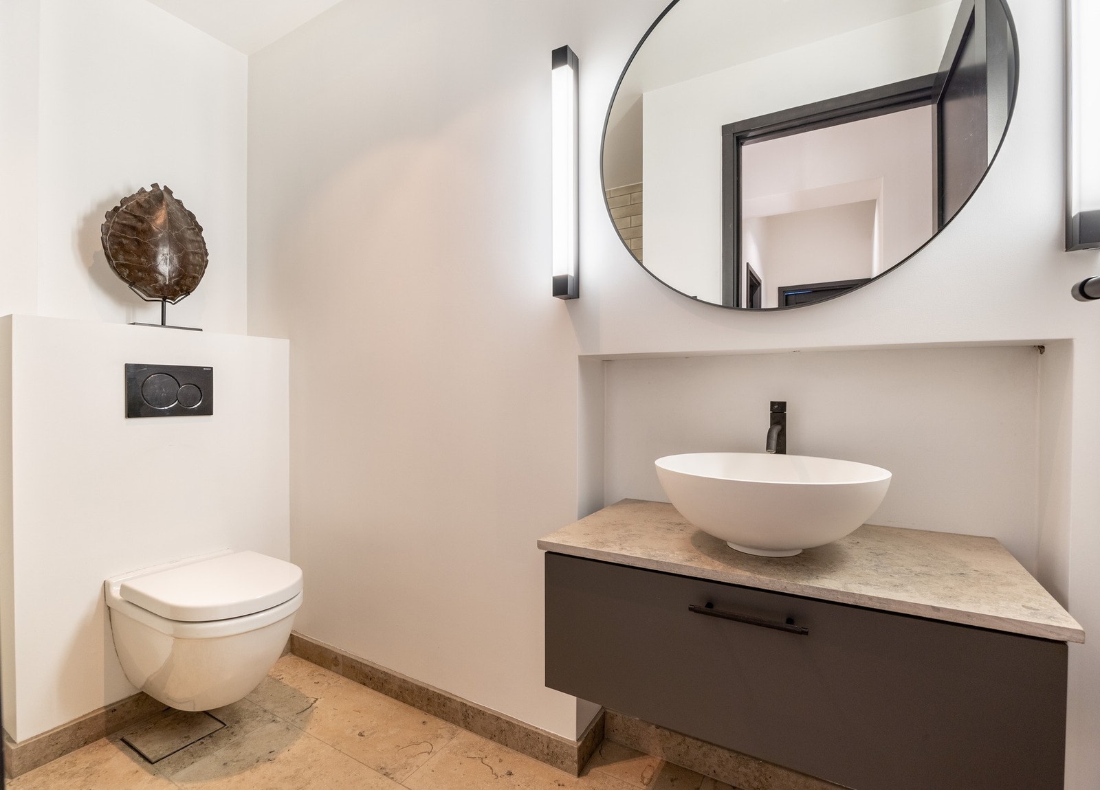 Badene er innredet i samme fargepalett. De mørke tonene hentes opp i alle leilighetens rom, som skaper et helhetlig og elegant uttrykk. Galleribilde