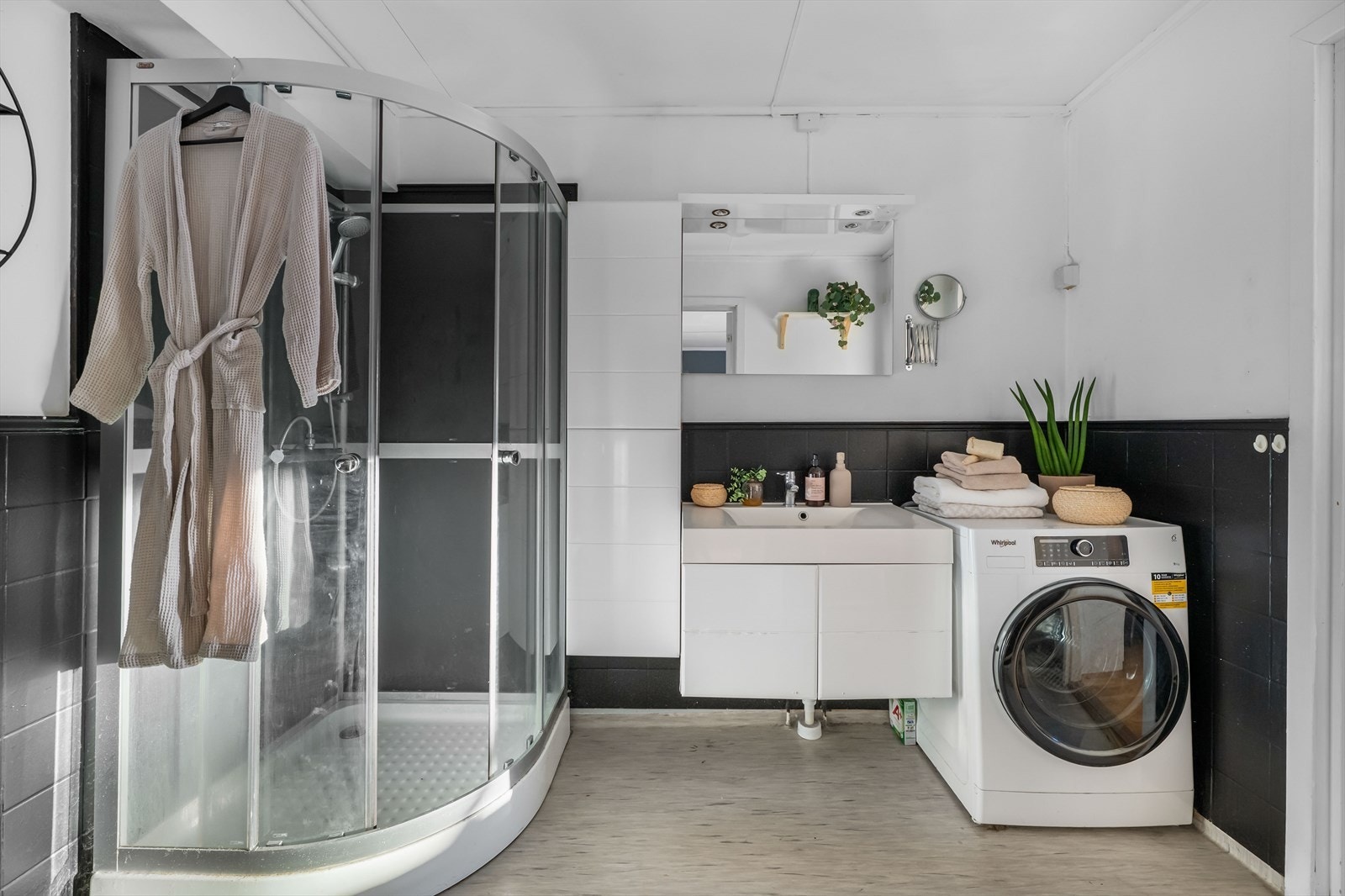 Badet er utstyrt med varme i gulv, dusjkabinett, gulvstående wc, servantmøbel og speil Galleribilde