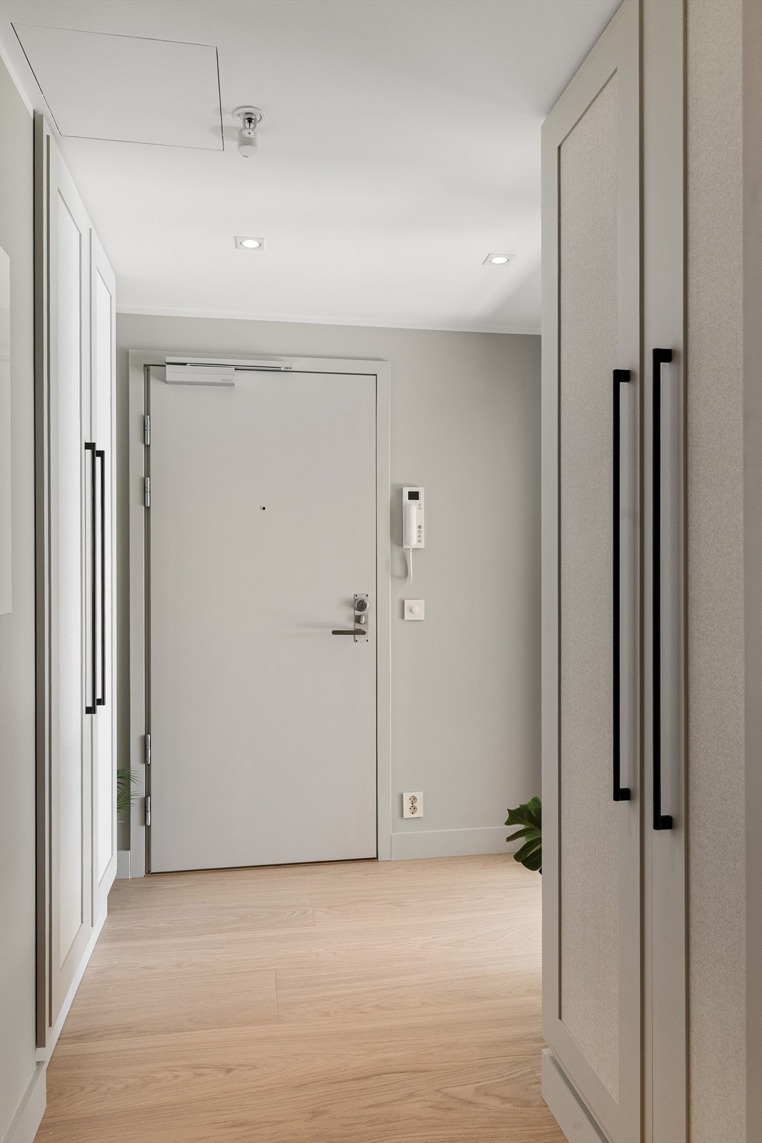Leiligheten åpner seg med en innbydende entré med downlights, og det plassbygde garderobeskapet tilbyr praktisk oppbevaring av yttertøy. Galleribilde